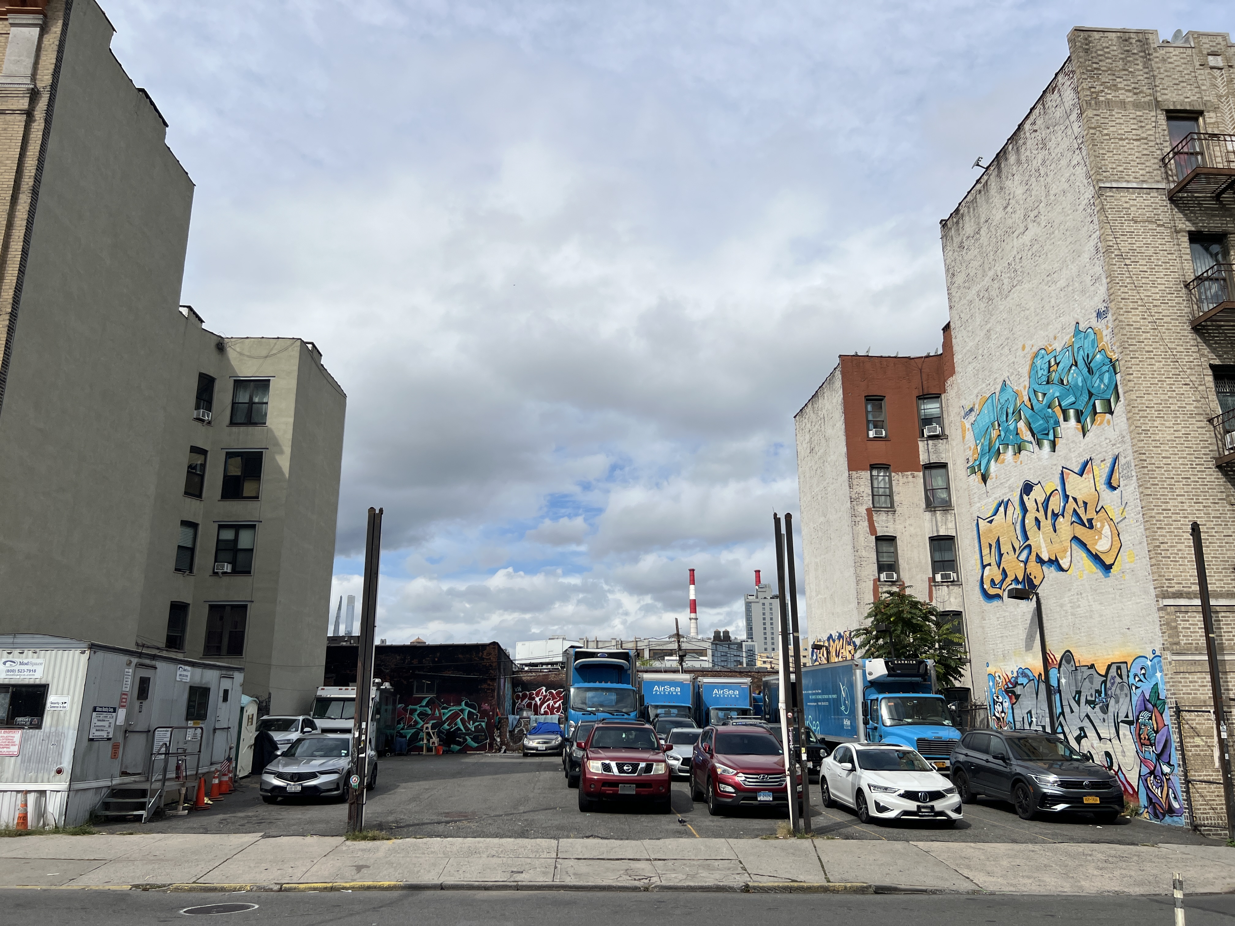 a city street lined with parked cars and buildings