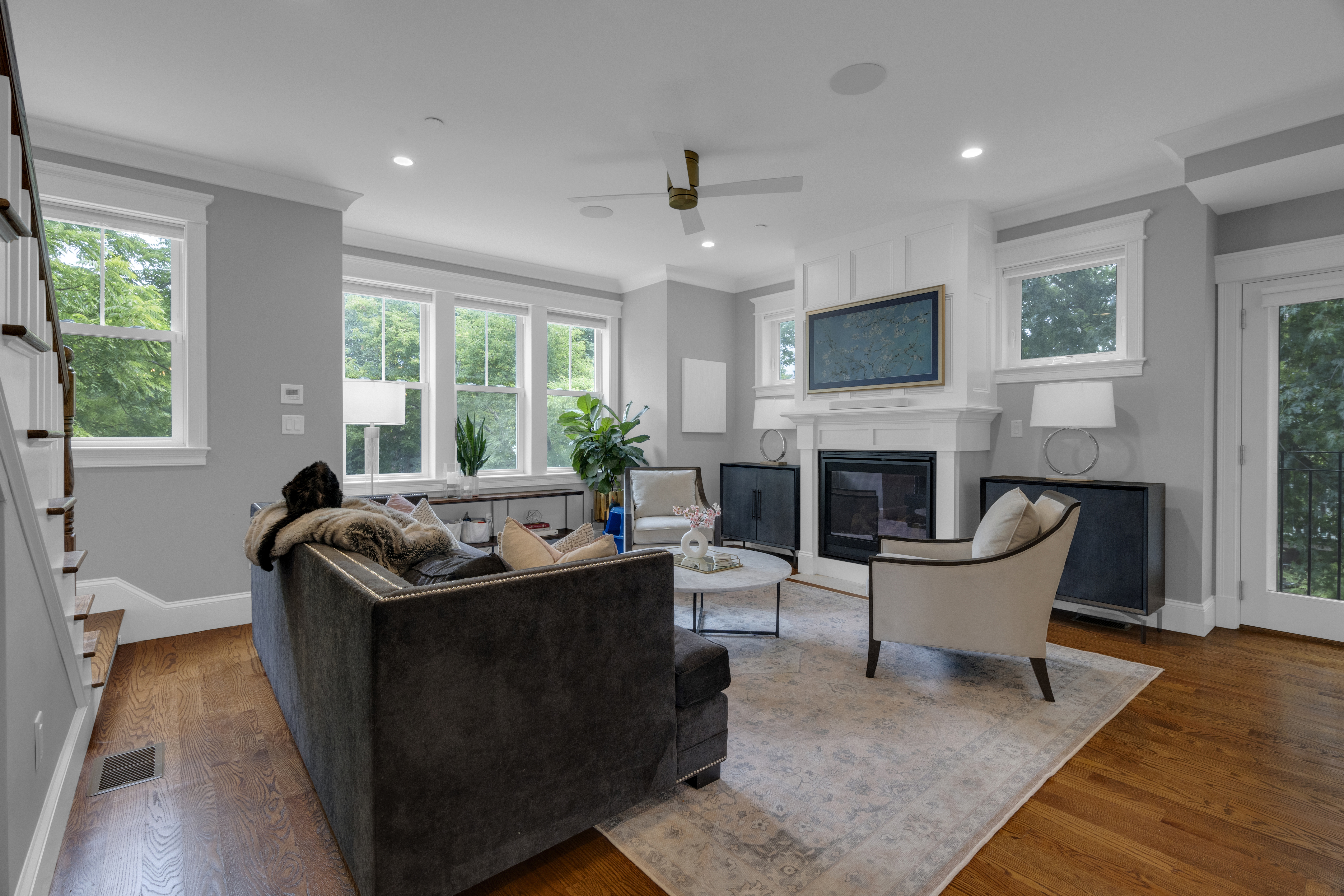 a living room with fireplace furniture and a large window