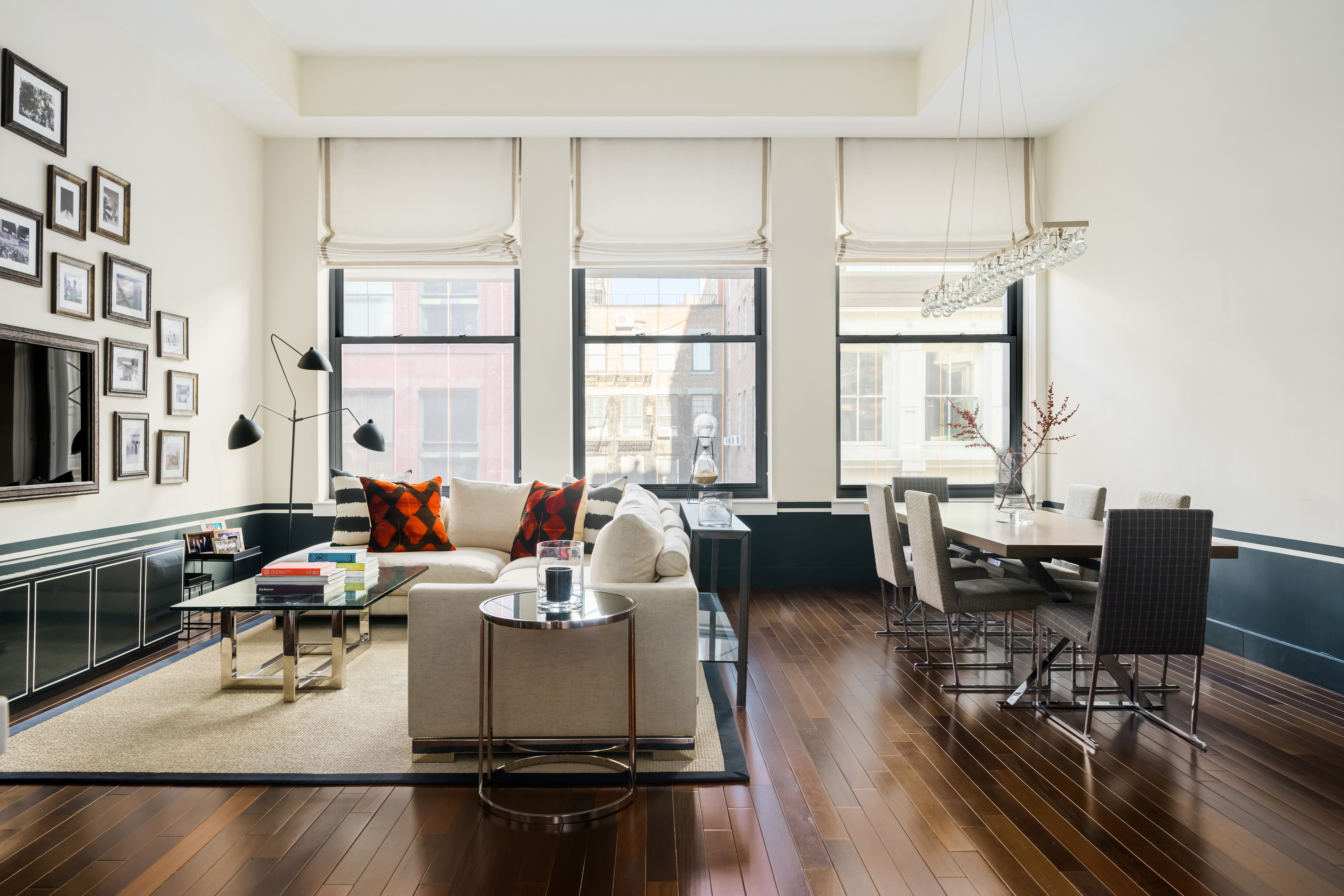 a living room with furniture and floor to ceiling windows