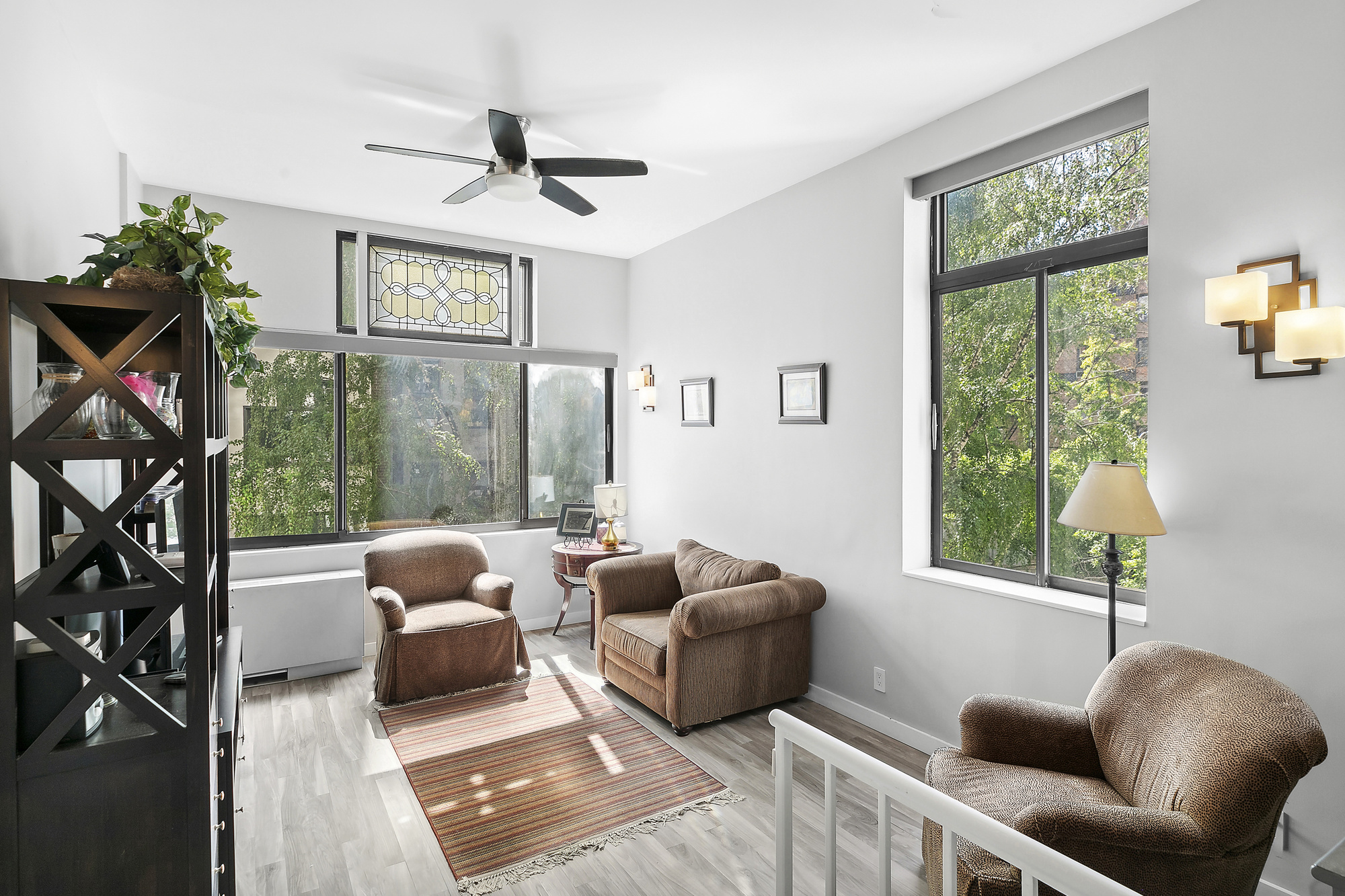 a living room with furniture a floor to ceiling window and a flat screen tv