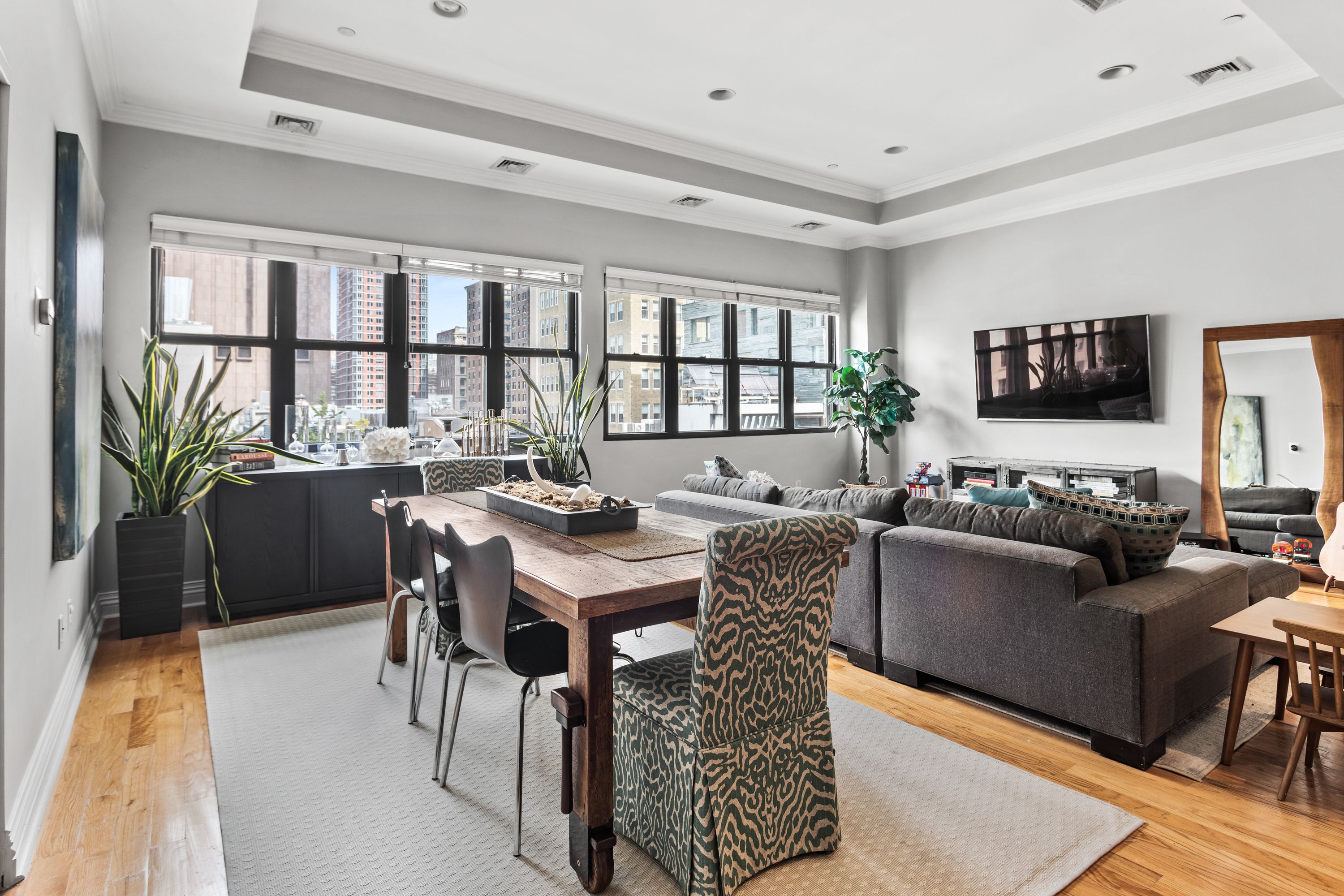 a living room with furniture a flat screen tv and a floor to ceiling window