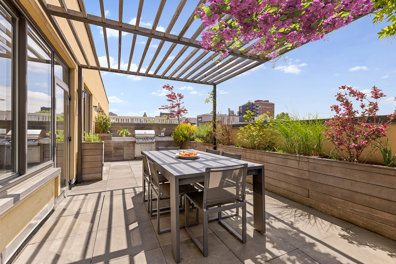 a view of a patio with table and chairs with wooden floor and plants