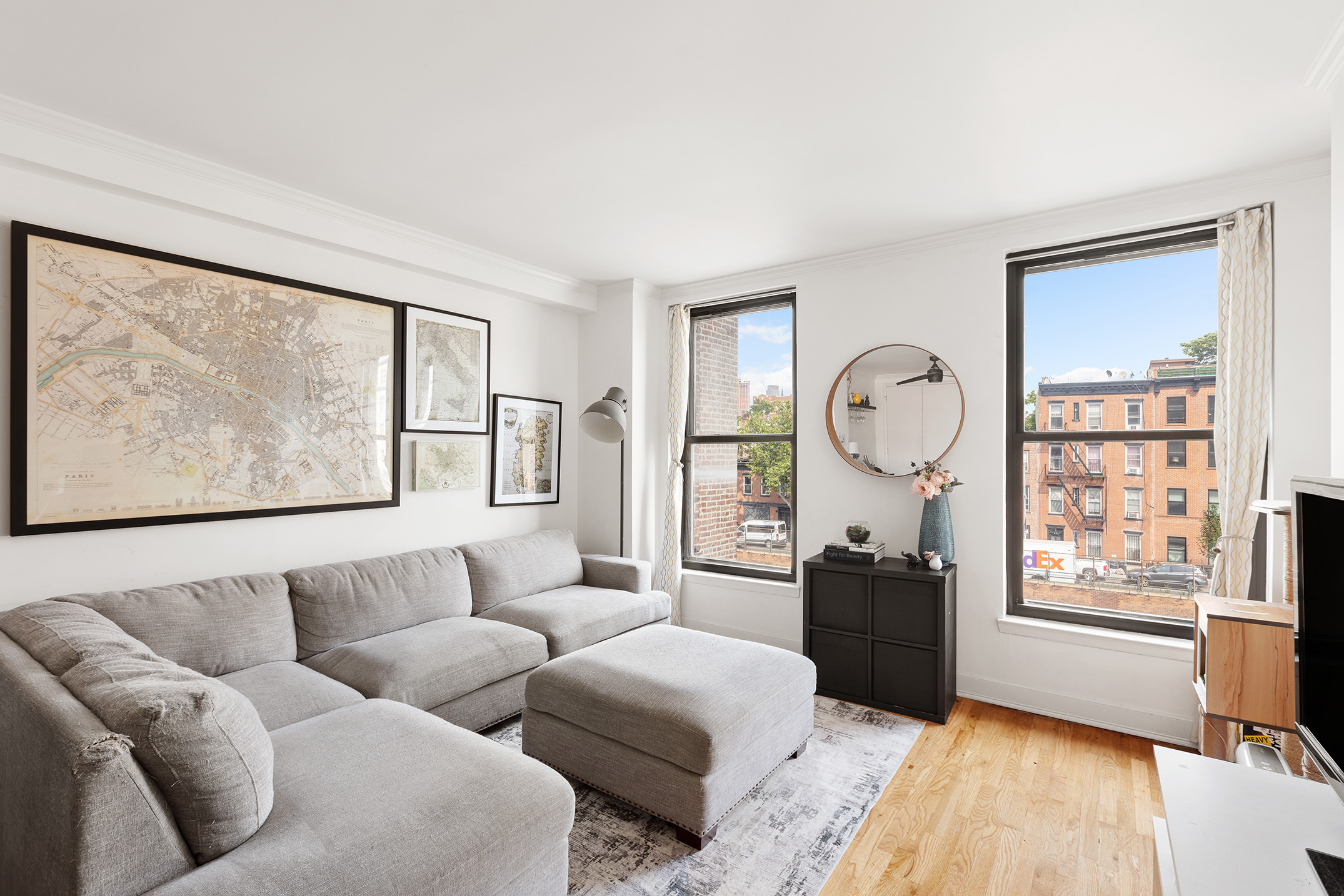 a living room with furniture a large window and wooden floor