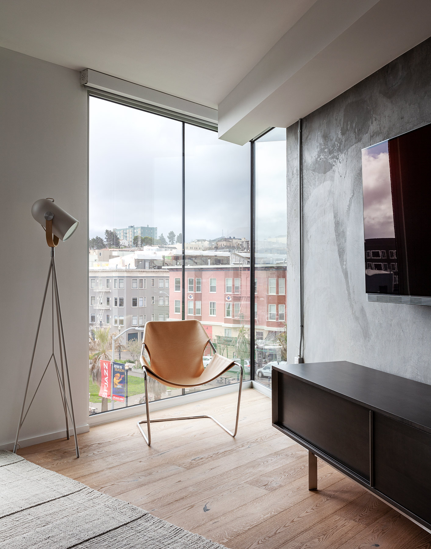 a living room with a floor to ceiling window and a flat screen tv