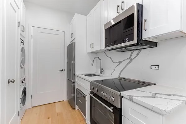 a kitchen with stainless steel appliances granite countertop a sink stove and microwave