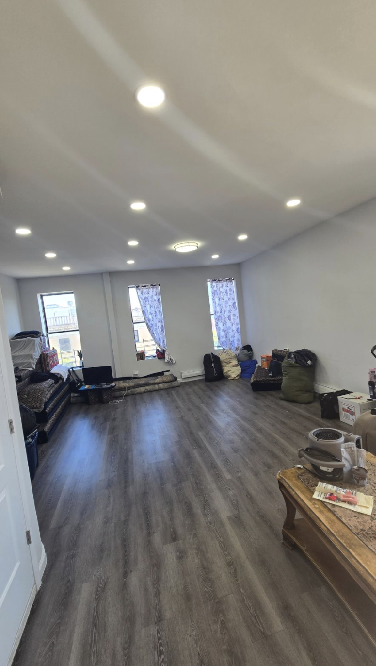 a view of a room with gym equipment and wooden floor