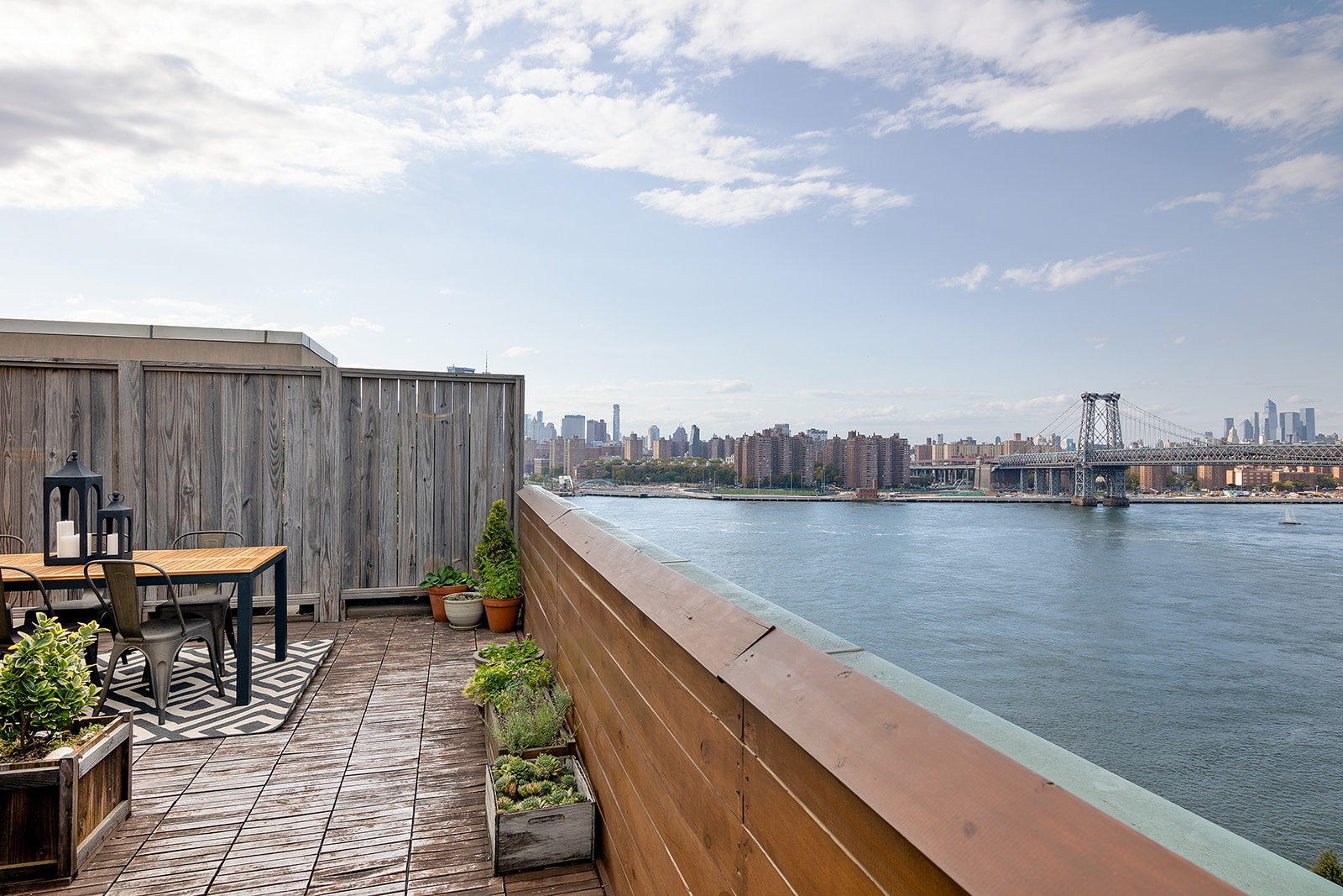 a balcony with wooden benches and lake view