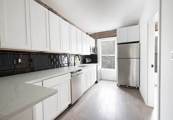 a kitchen with stainless steel appliances a refrigerator sink and cabinets