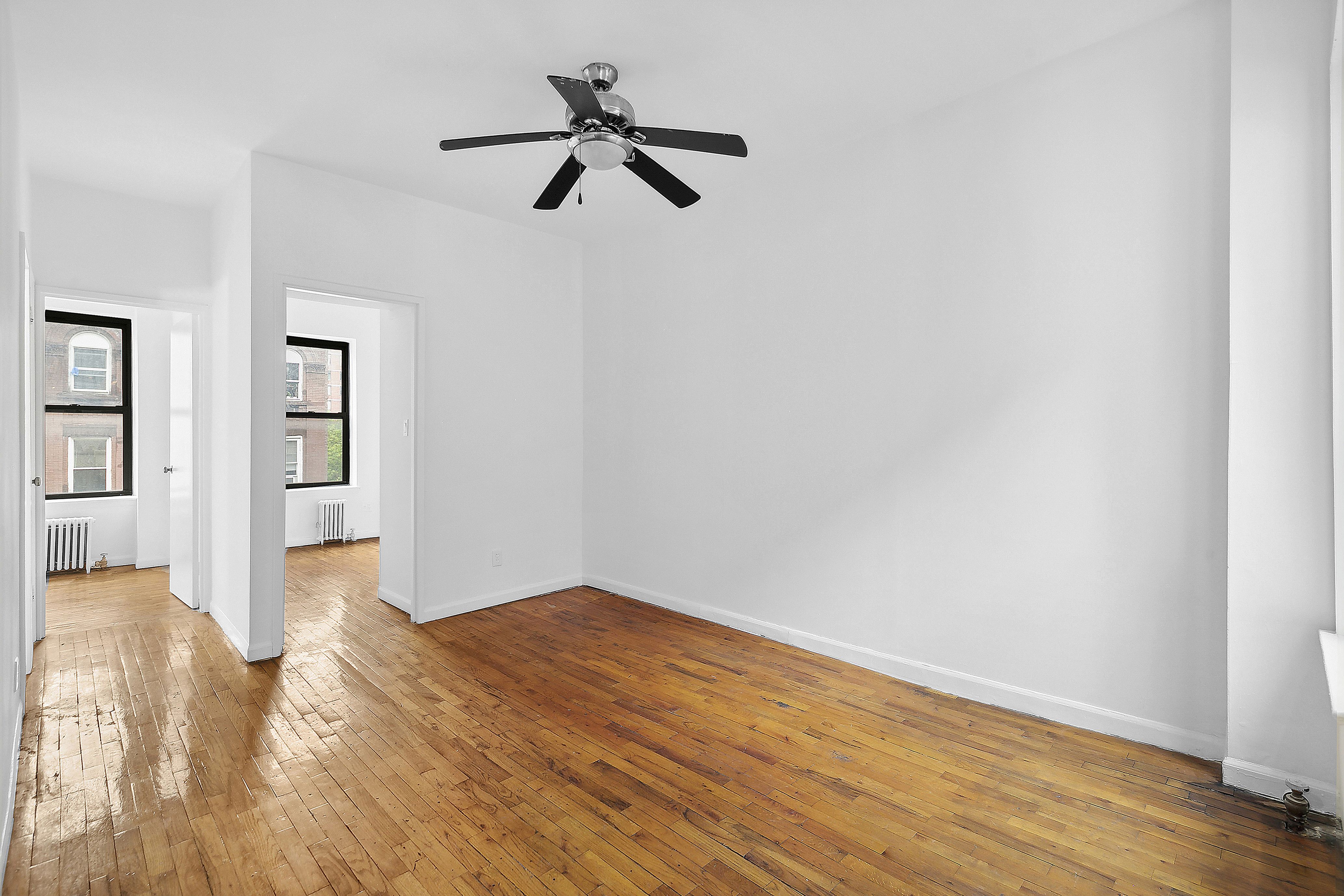 a view of empty room with wooden floor