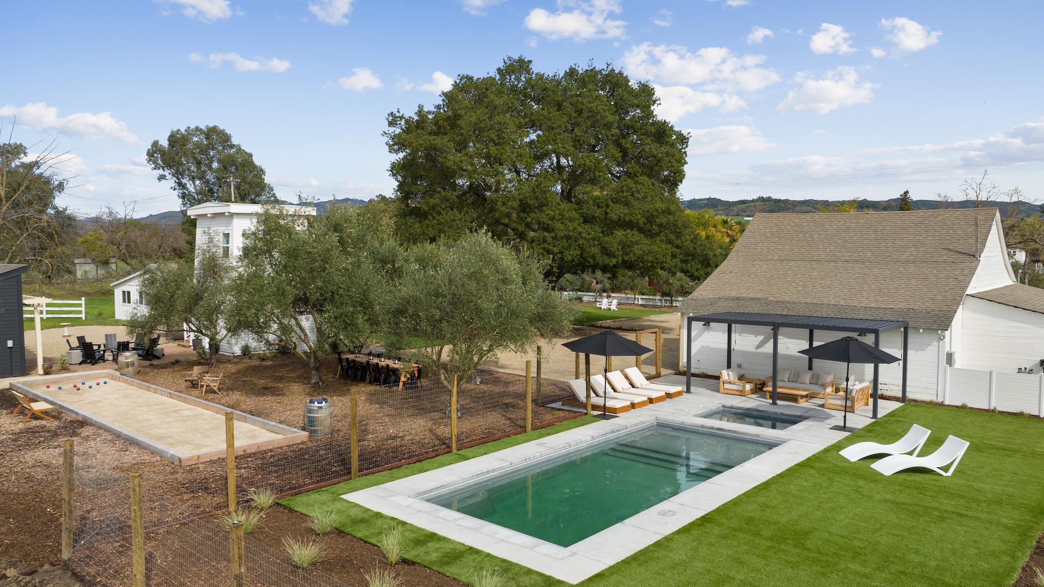 a view of a swimming pool with lawn chairs and a fire pit