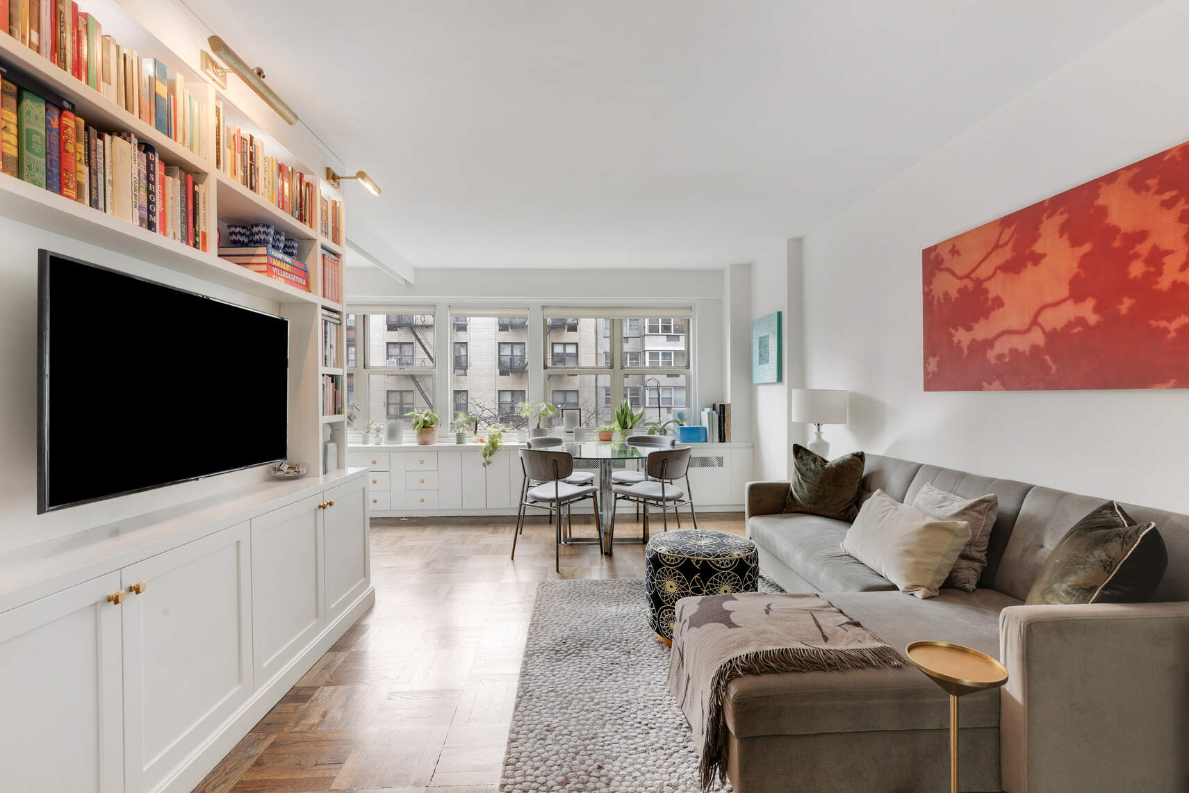 a living room with furniture a flat screen tv and a floor to ceiling window