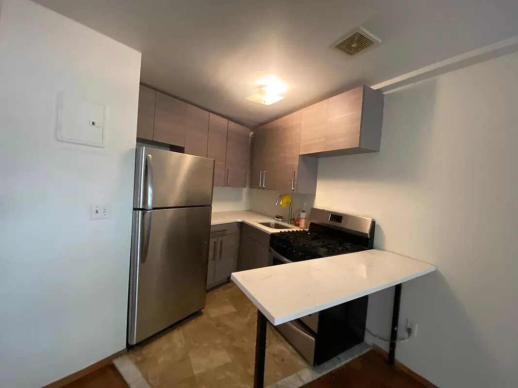 a kitchen with stainless steel appliances a refrigerator and a stove top oven