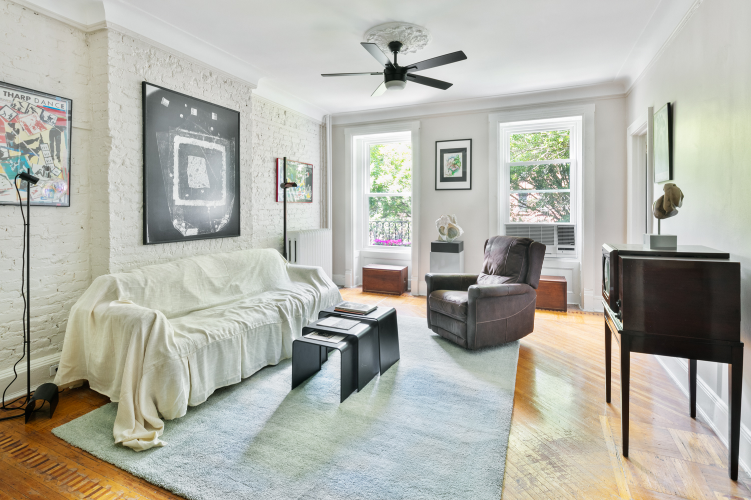 a bedroom with a bed couch and windows