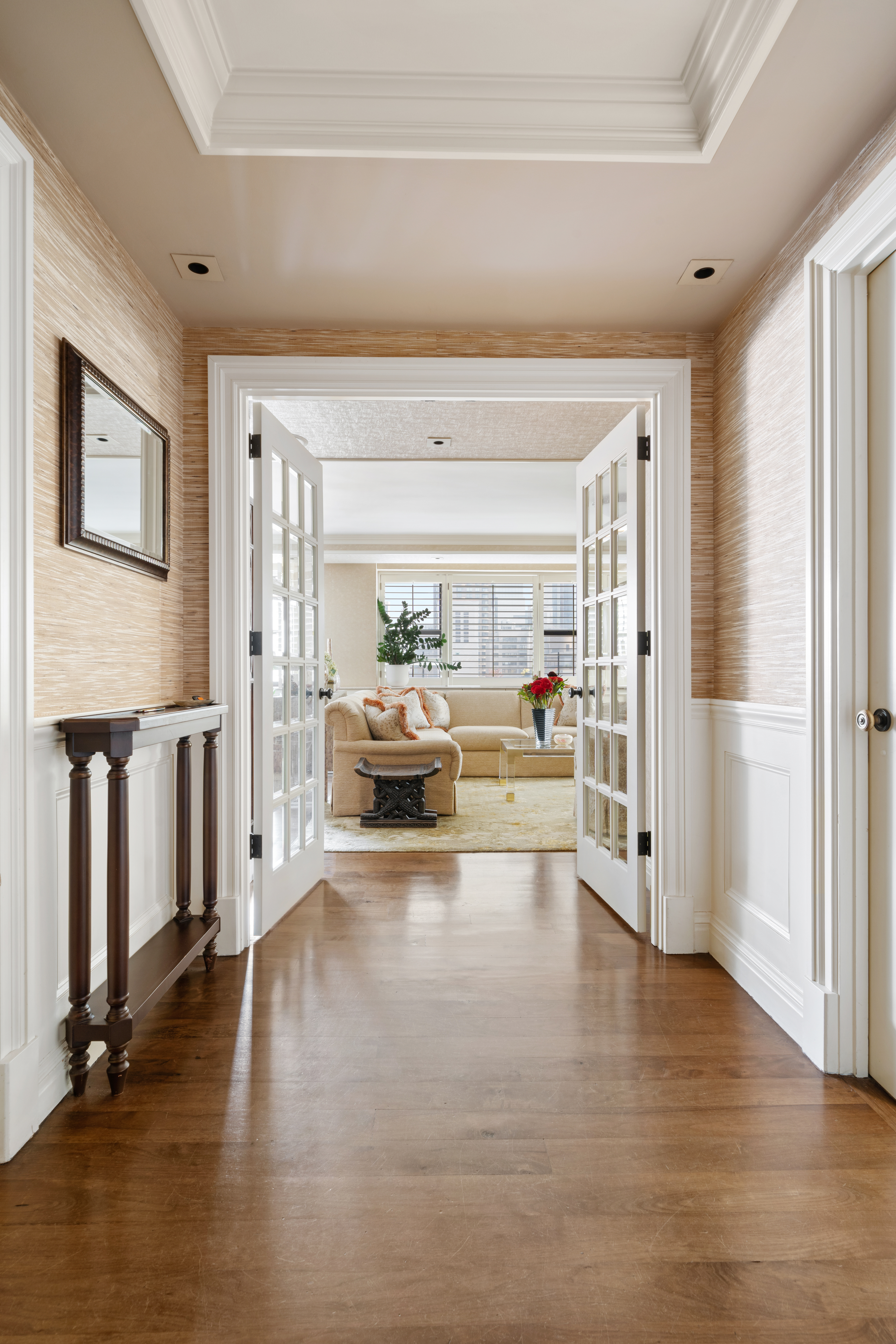 a living room with furniture floor to ceiling window and kitchen view