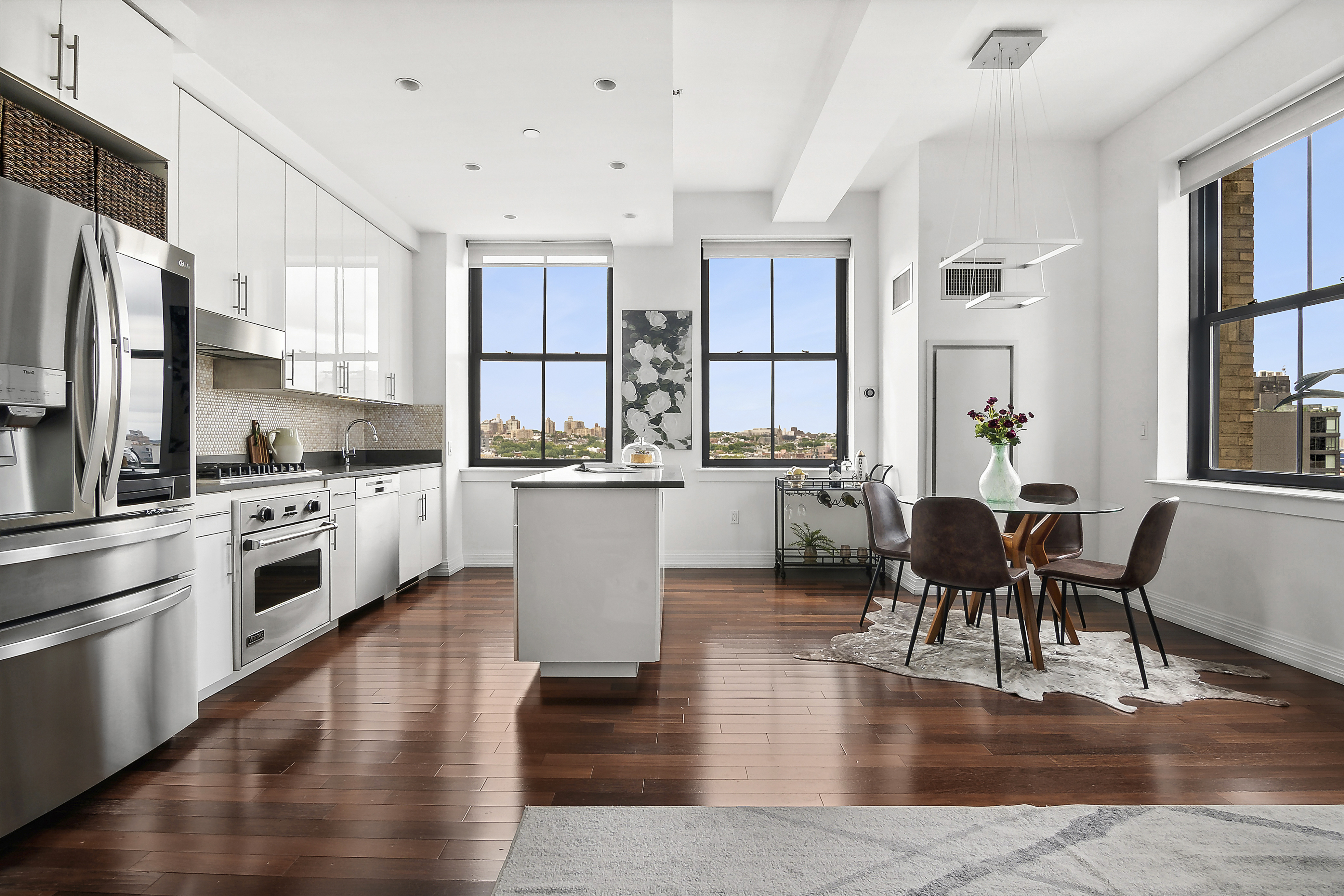 a open kitchen with white cabinets and stainless steel appliances