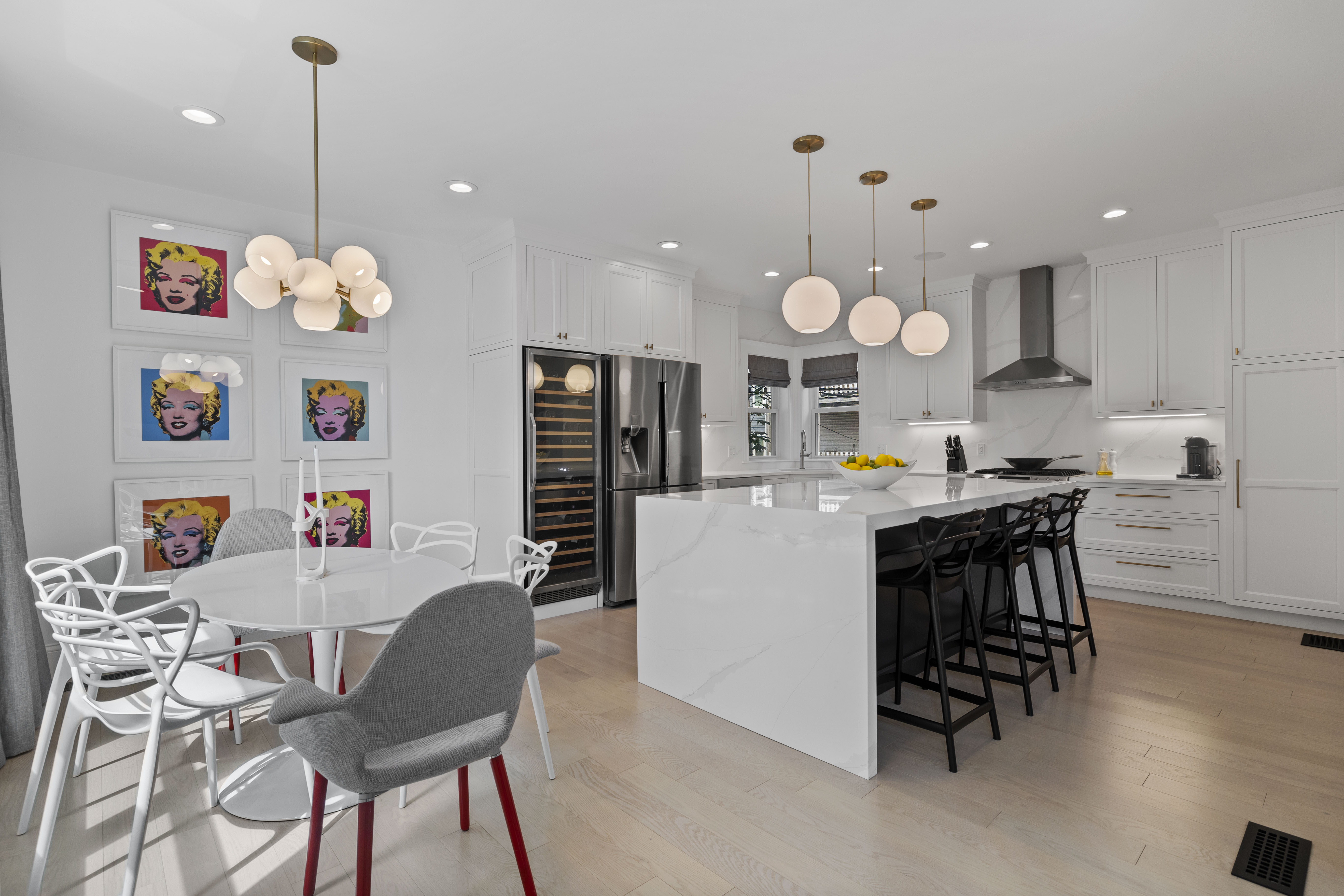 a kitchen with a dining table chairs sink and white cabinets