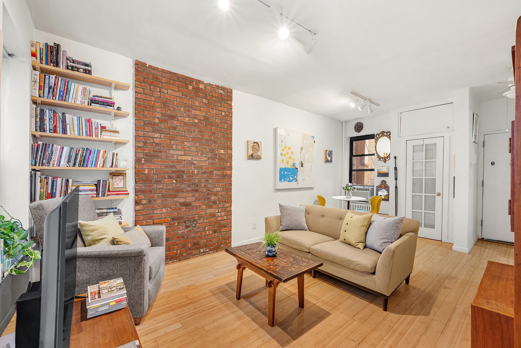 a living room with furniture and a book shelf