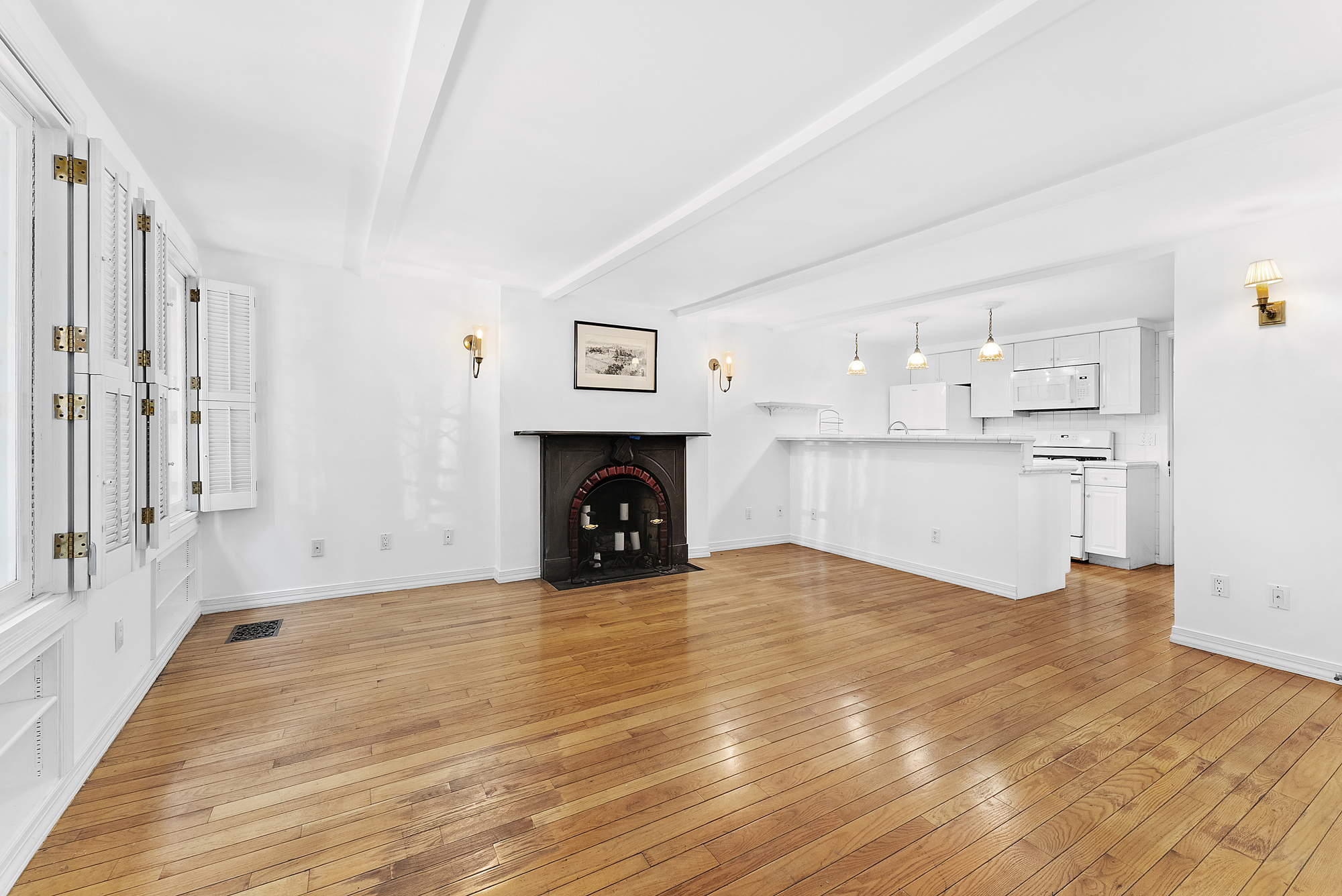 a view of empty room with wooden floor and fireplace