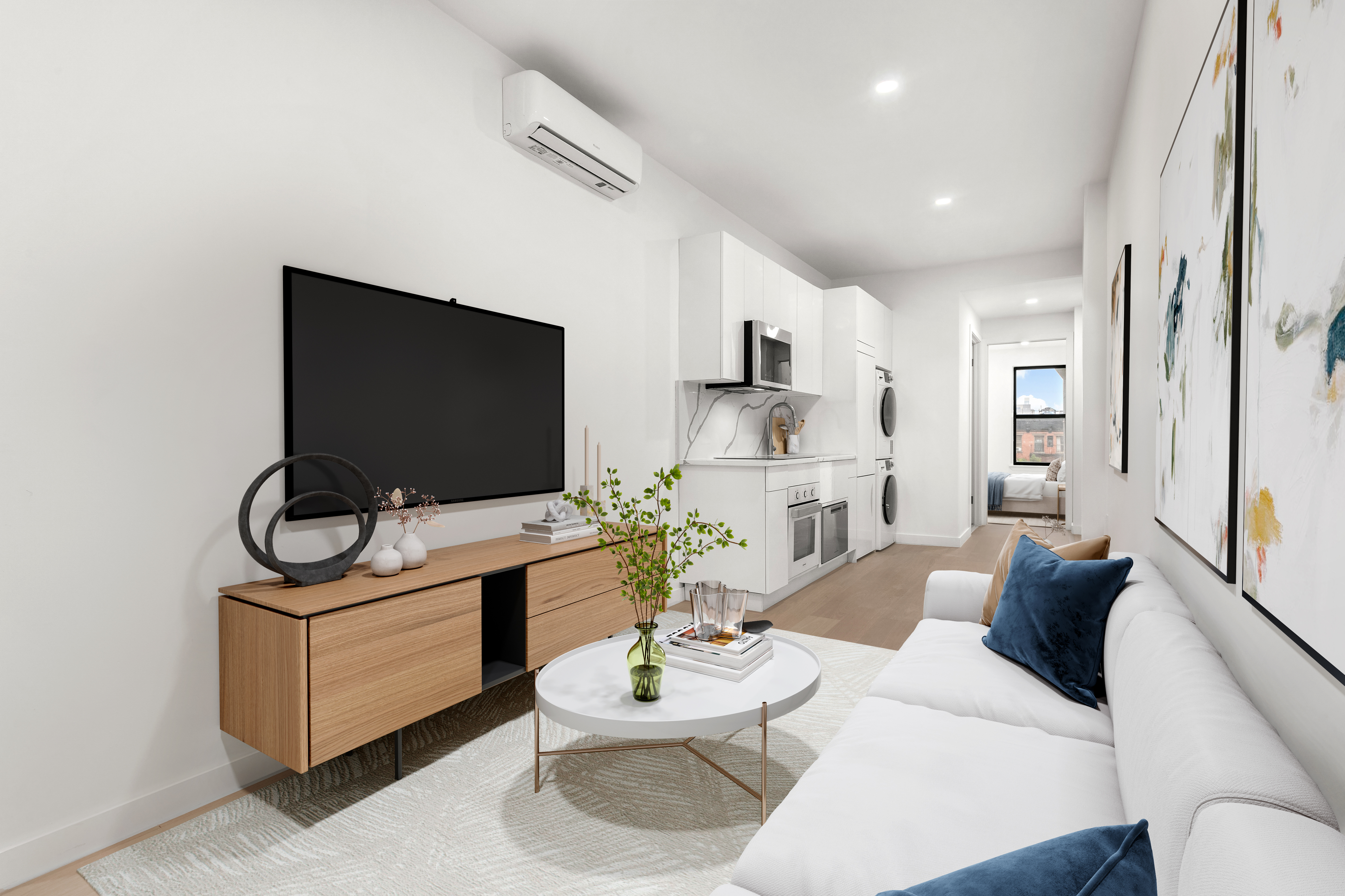 a living room with furniture a flat screen tv and kitchen view