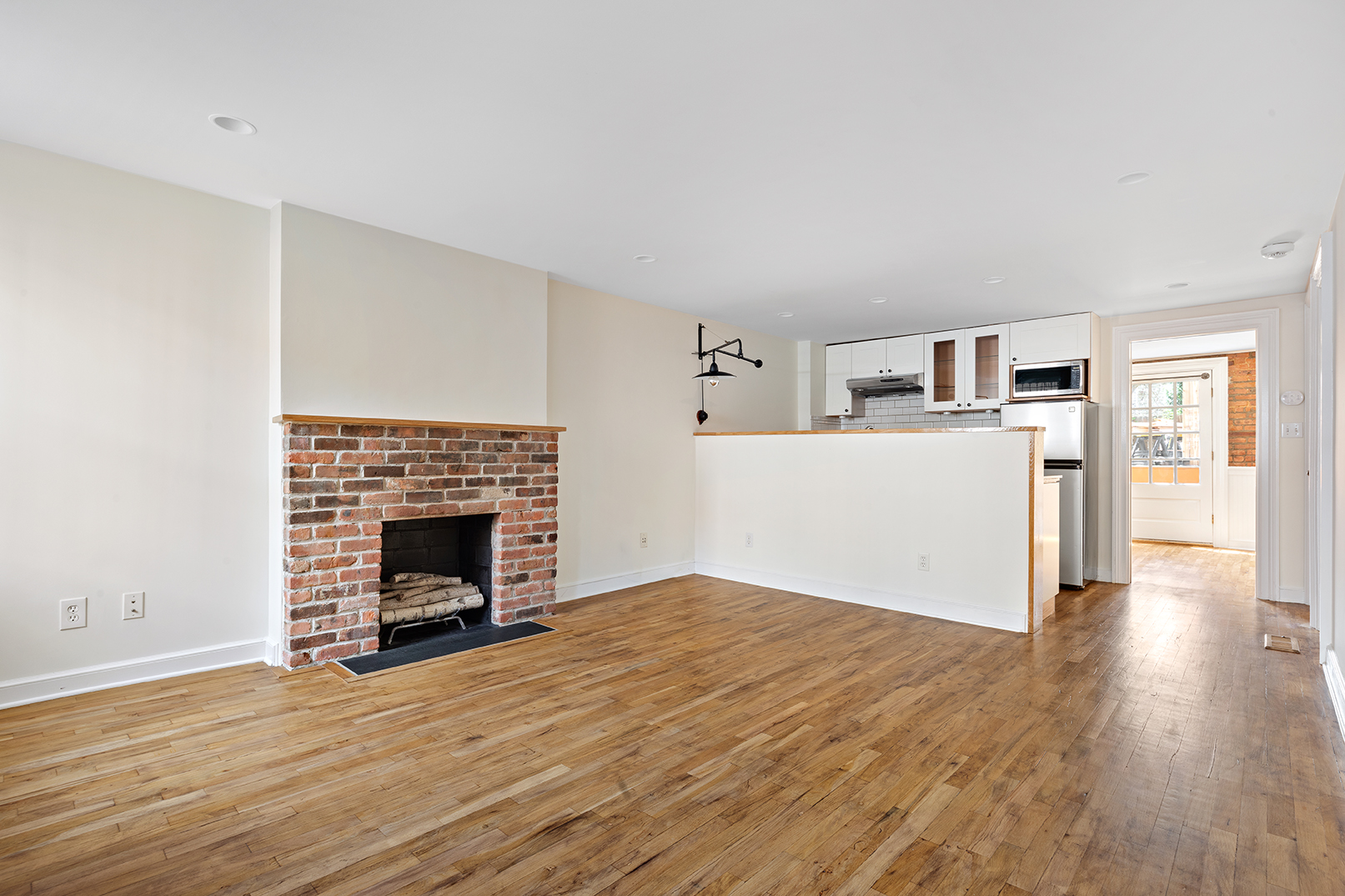 a view of empty room with wooden floor and fireplace