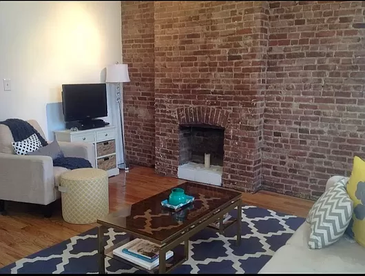 a living room with a couch a flat screen tv and a fireplace