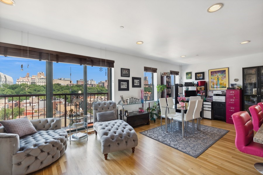 a living room with furniture large windows and wooden floor