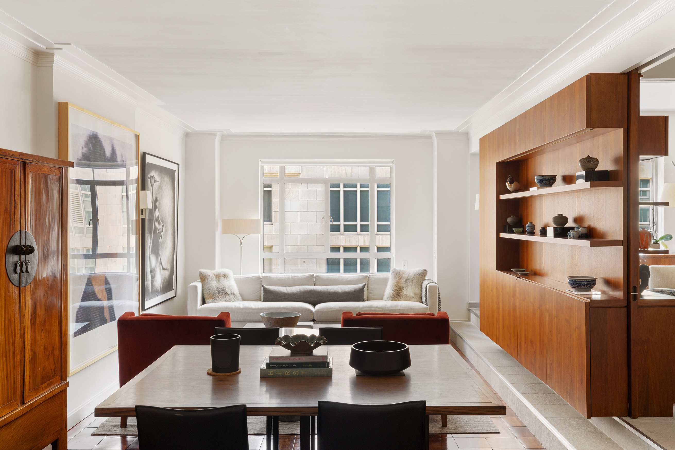 a living room with furniture kitchen view and large windows