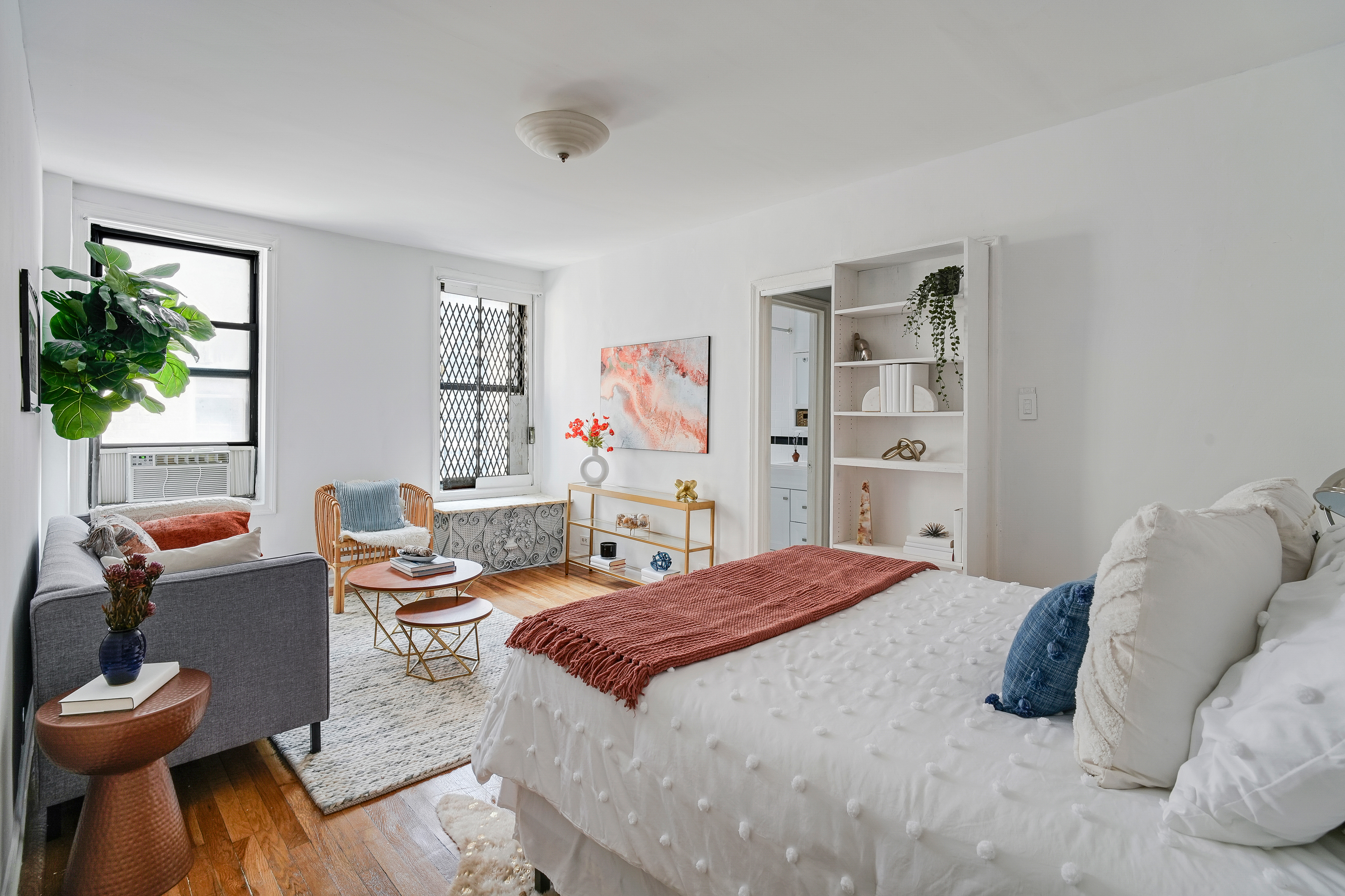 a bedroom with a bed and a bookshelf with wooden floor