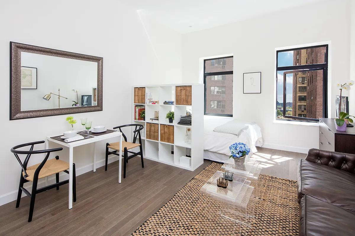 a living room with furniture a wooden floor and next to a window