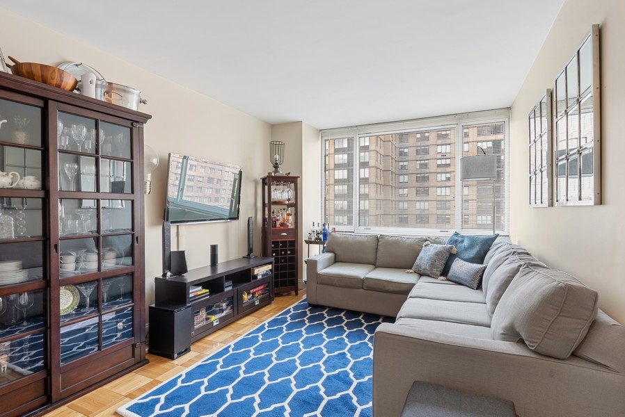 a living room with furniture and a floor to ceiling window