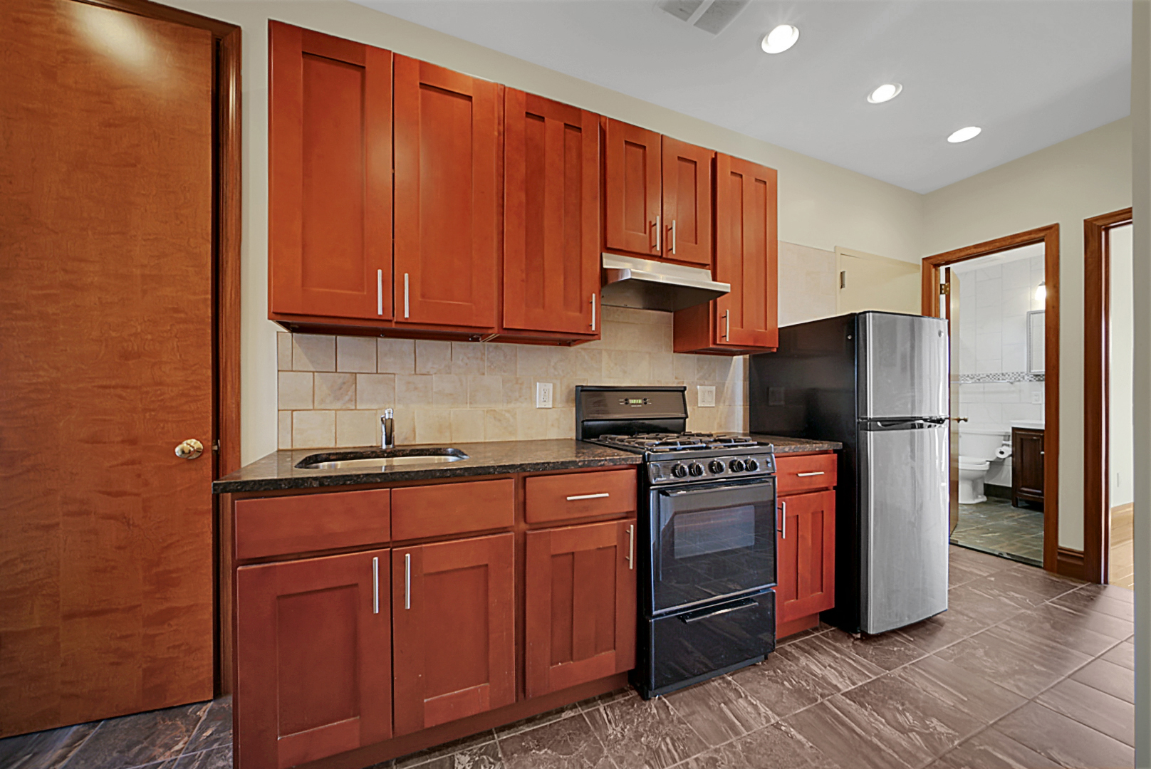 a kitchen with stainless steel appliances granite countertop a refrigerator stove and sink