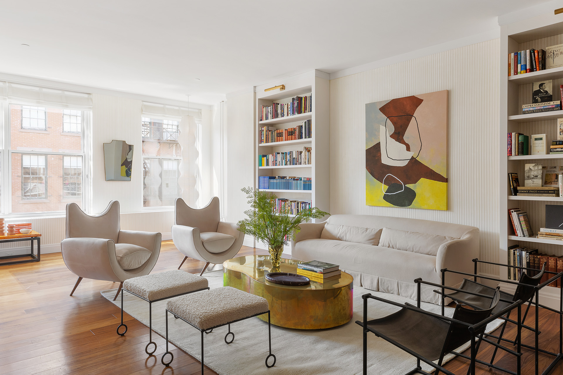 a living room with furniture and paintings on the wall