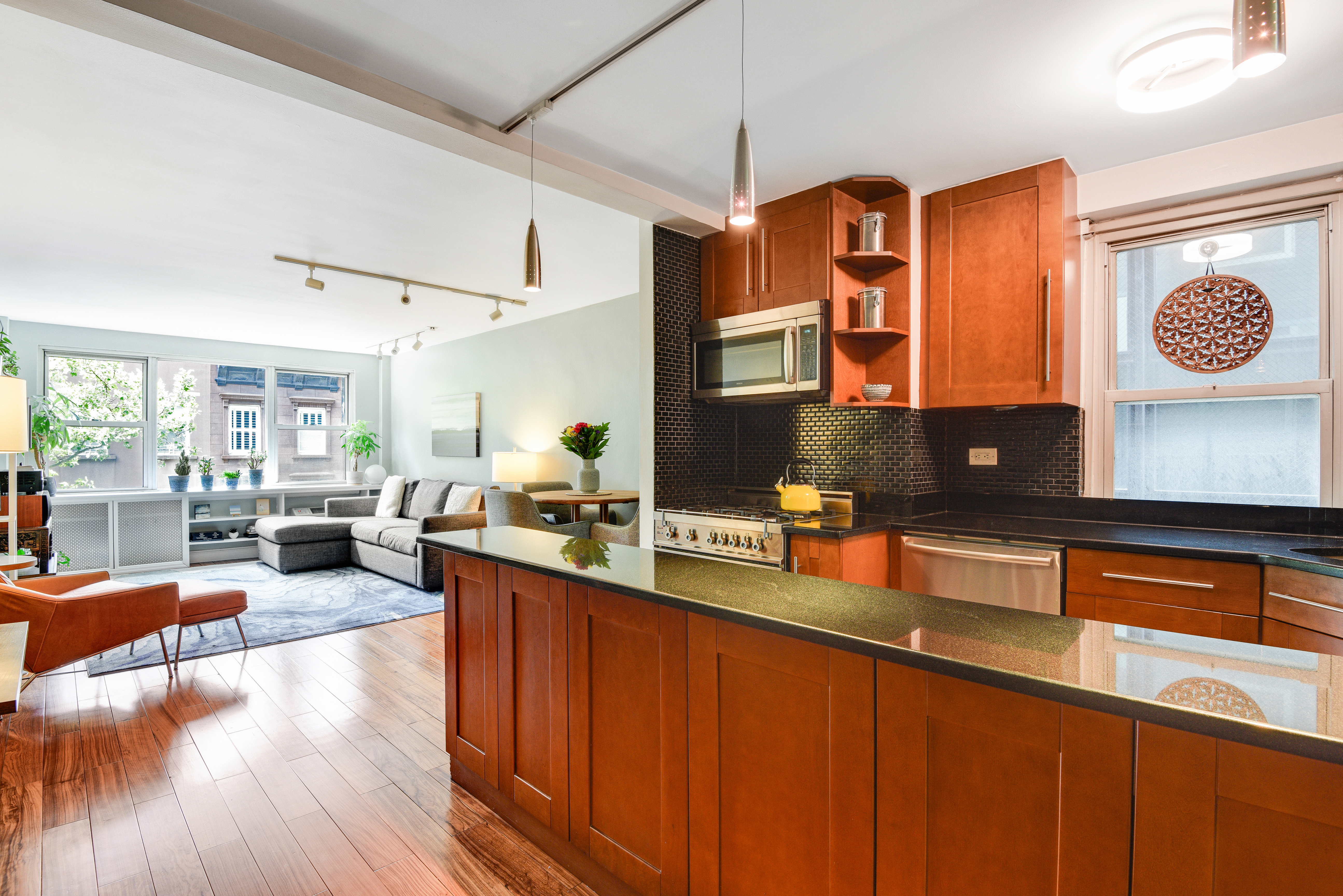 a kitchen with stainless steel appliances granite countertop a sink dishwasher stove and wooden cabinets