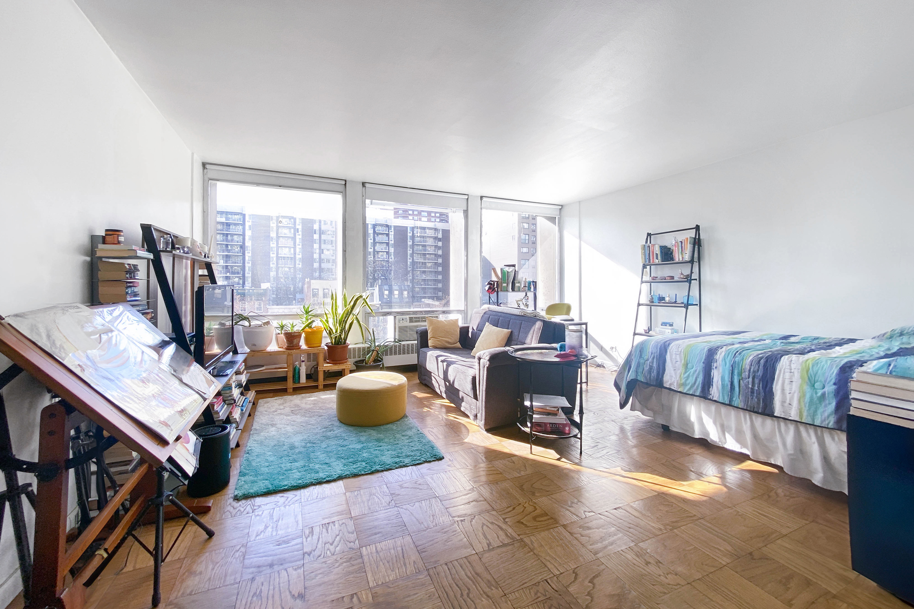 a living room with furniture a large window and a wooden floor