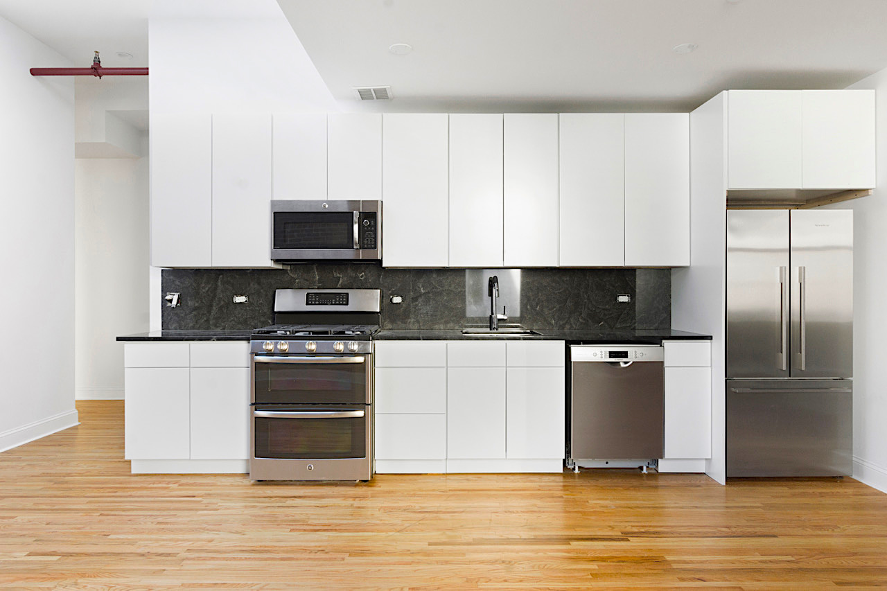 a kitchen with stainless steel appliances granite countertop a stove a sink and a refrigerator