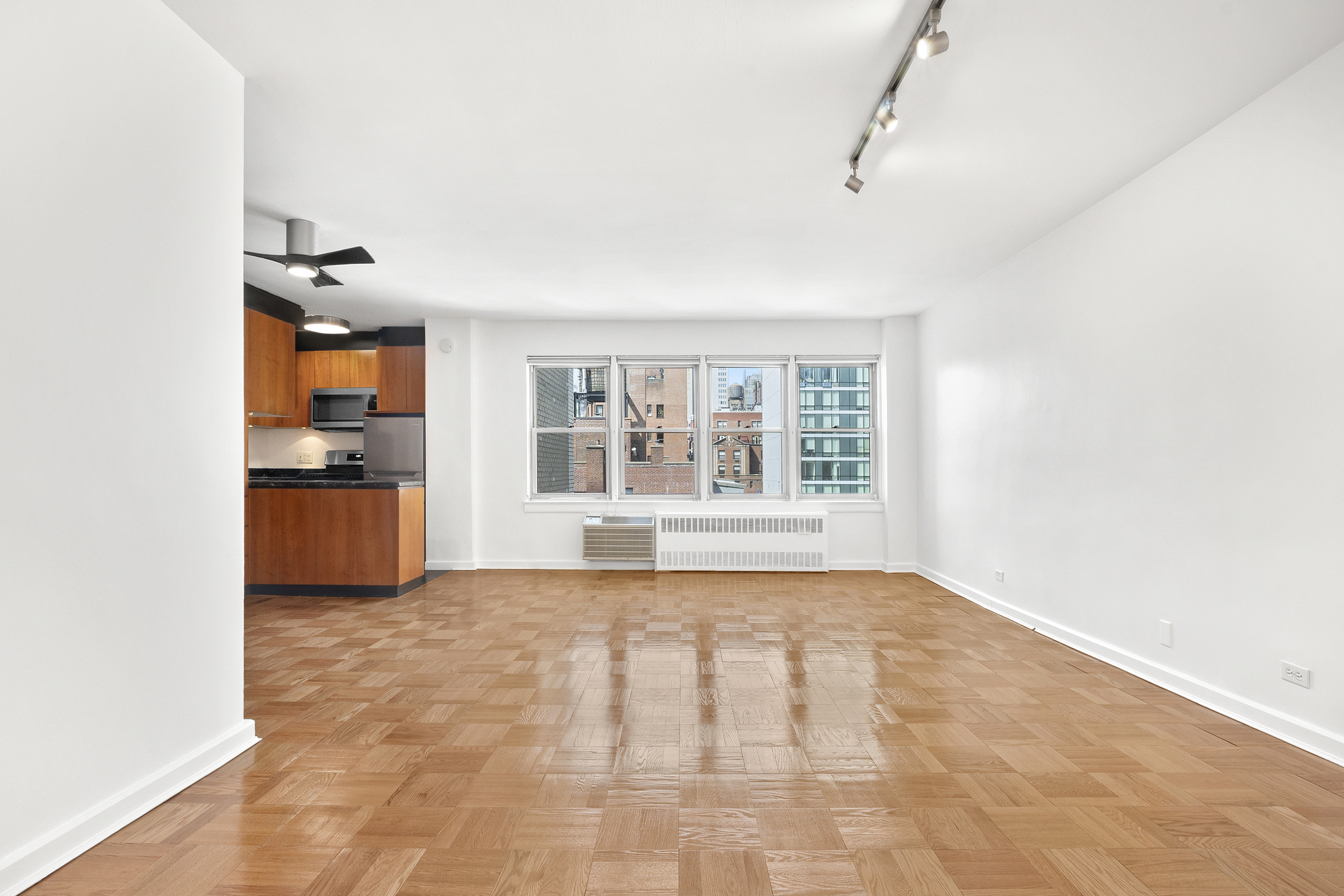 a view of empty room with wooden floor and window