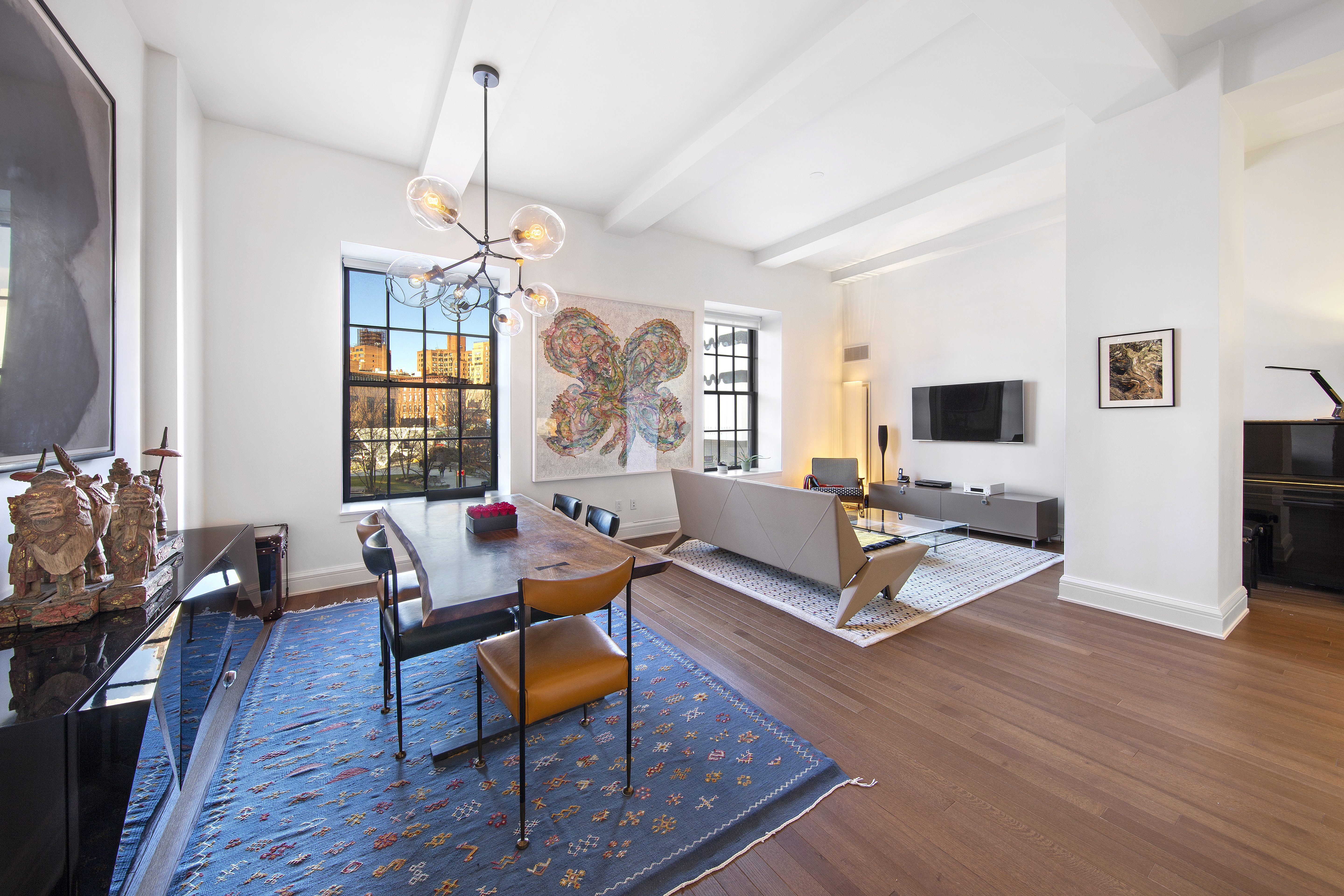 a living room with furniture a window and a flat screen tv