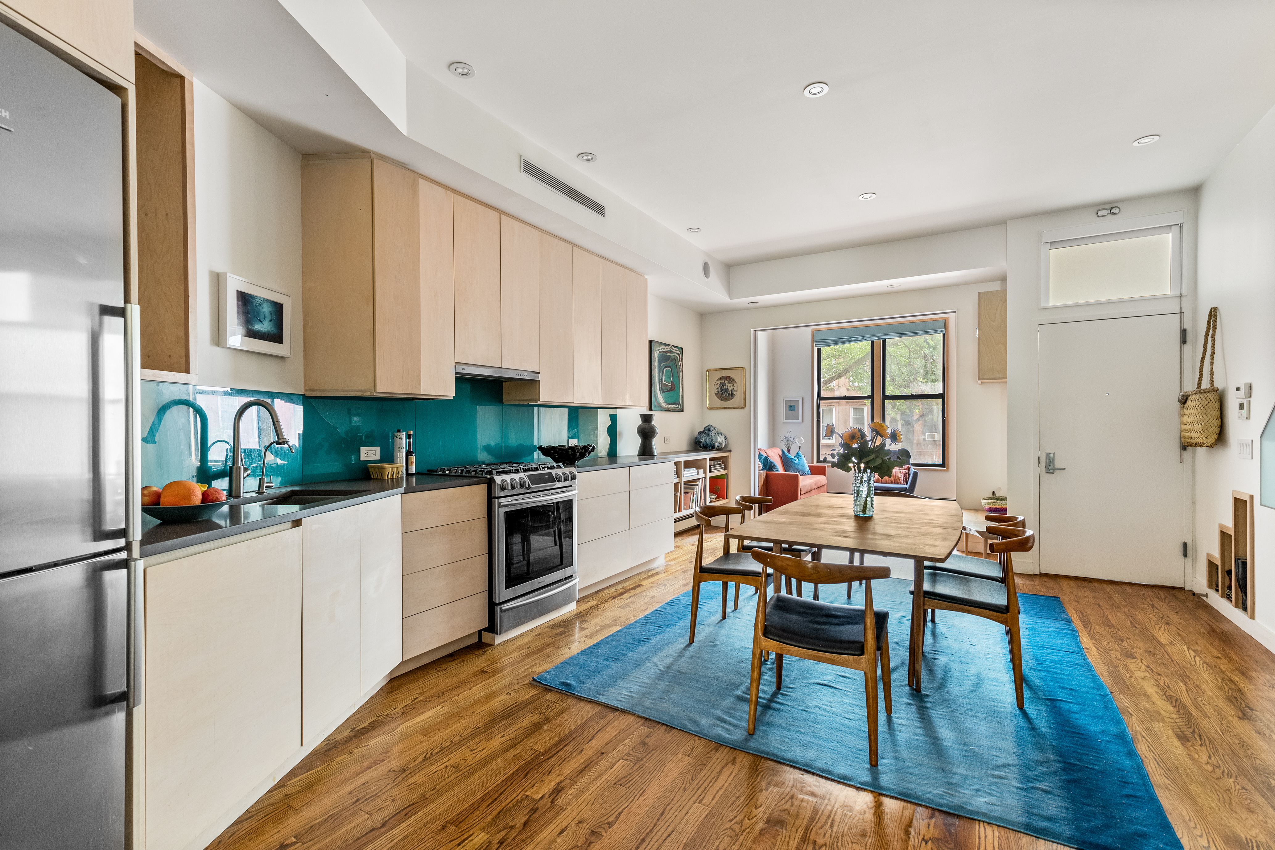 a kitchen with stainless steel appliances granite countertop wooden floors a stove and white cabinets