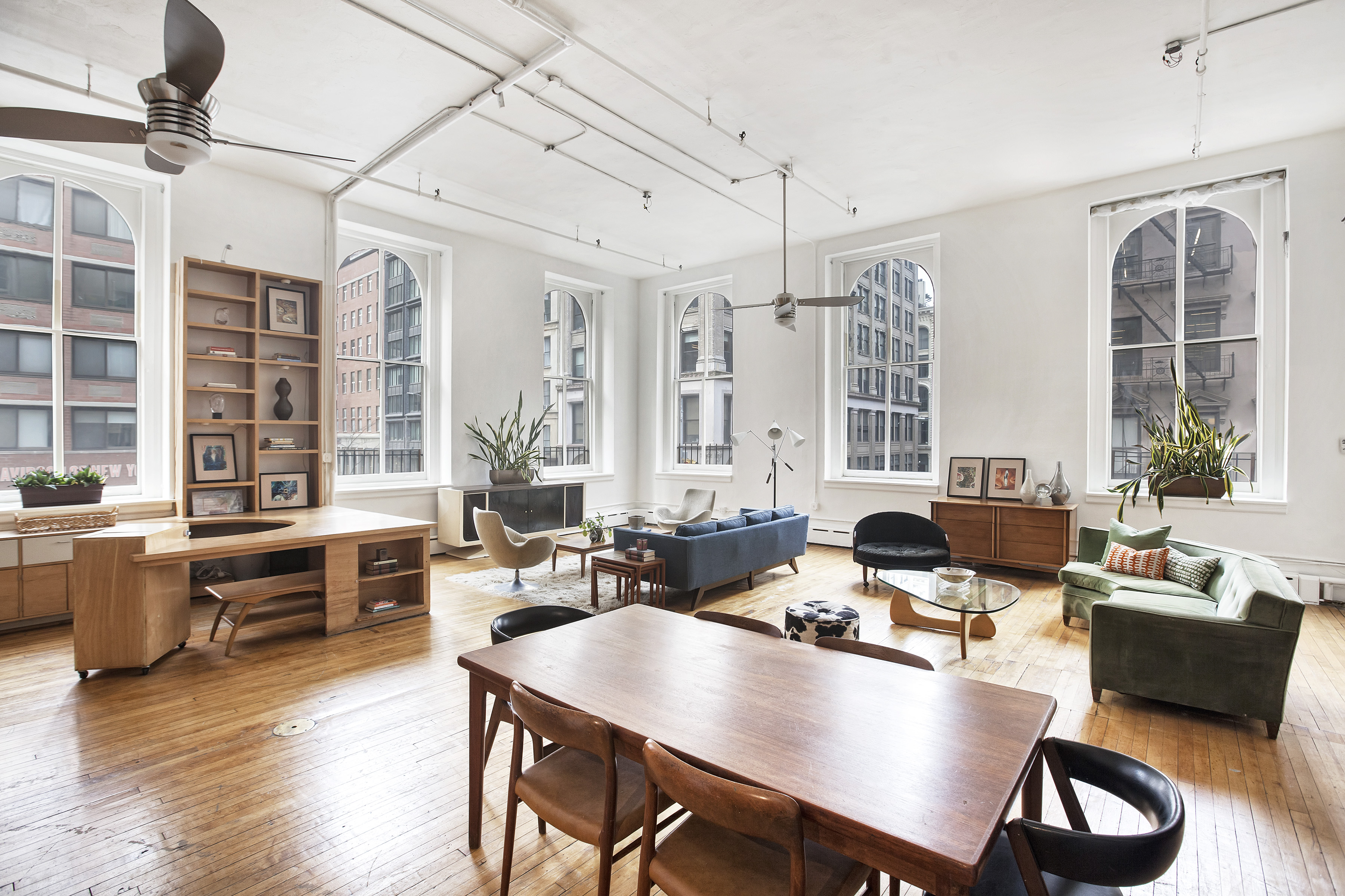 a living room with furniture floor to ceiling window and wooden floor