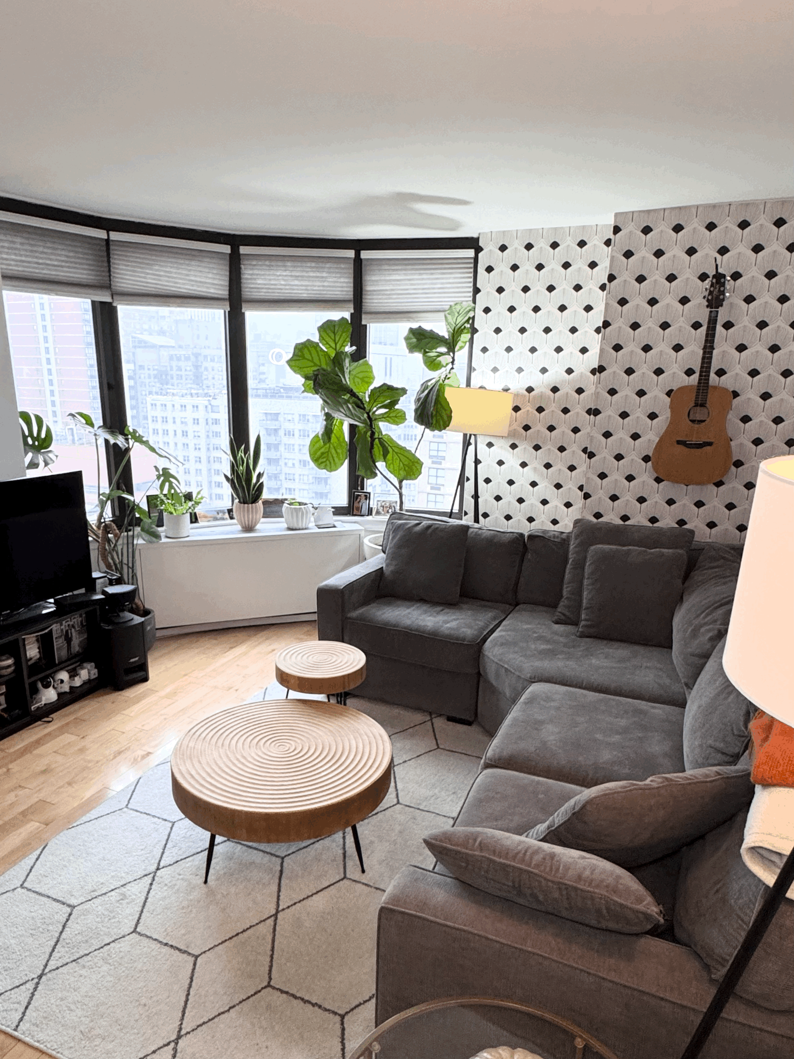 a living room with furniture a flat screen tv and a large window