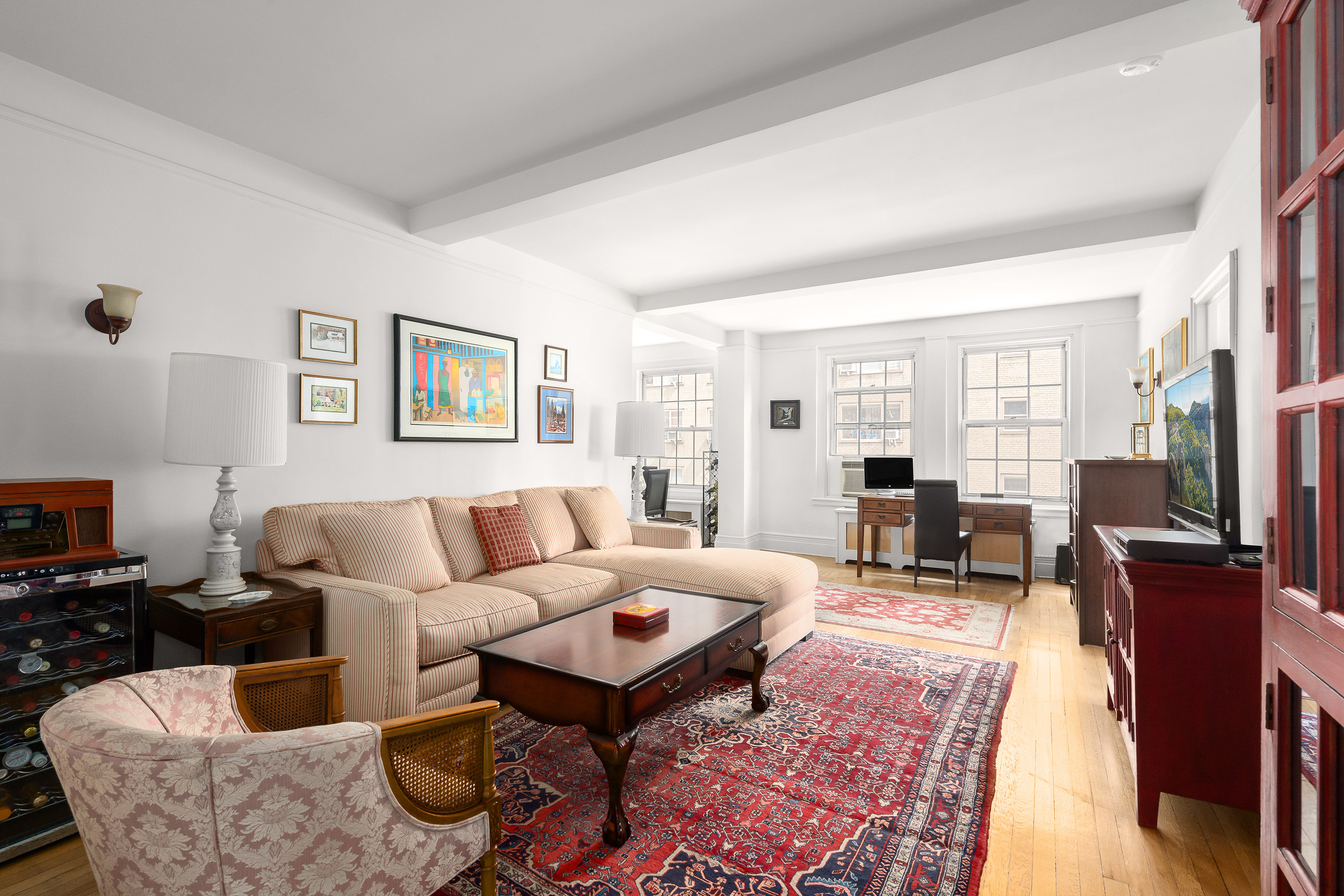 a living room with furniture a large window and a flat screen tv