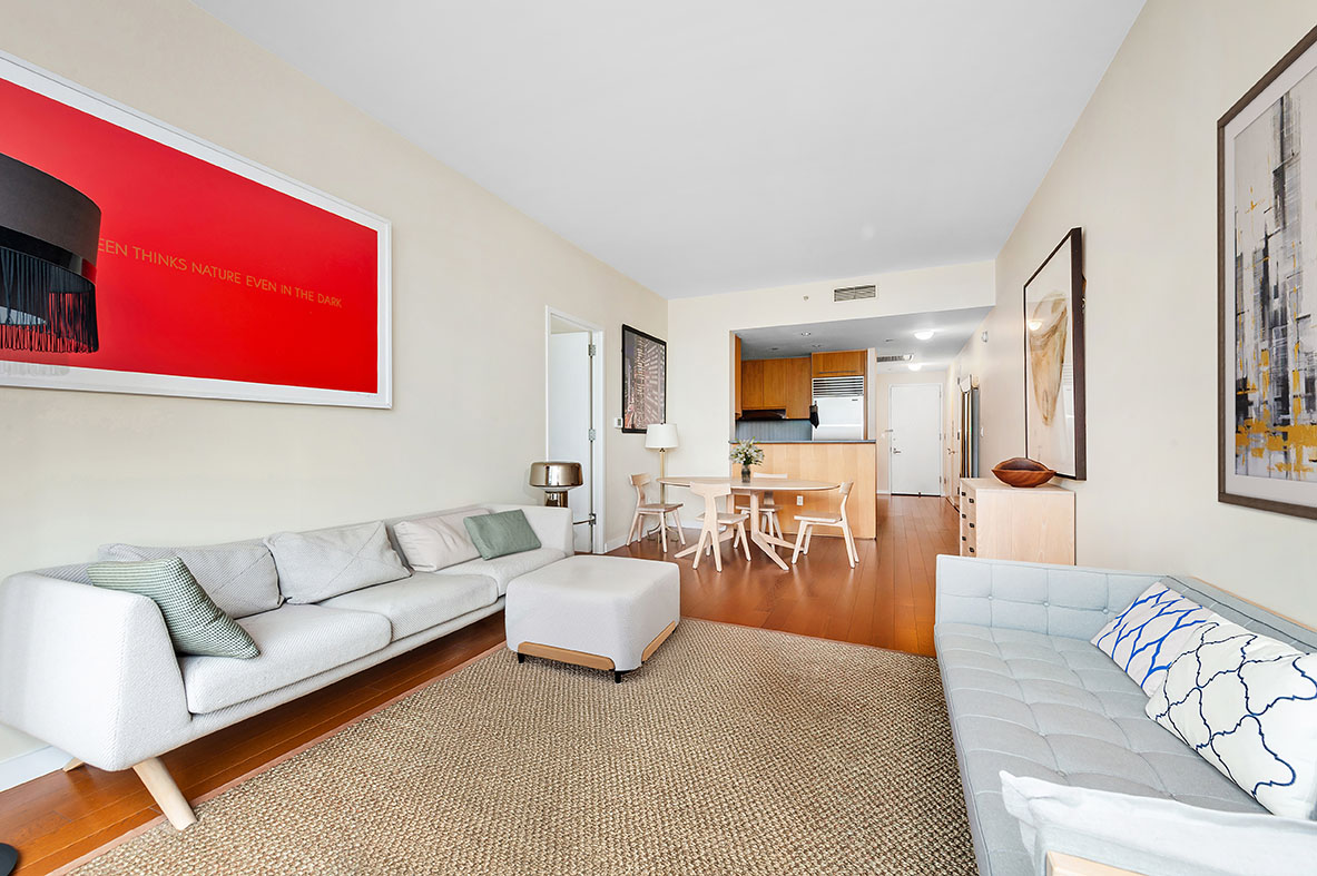 a living room with furniture kitchen view and a window