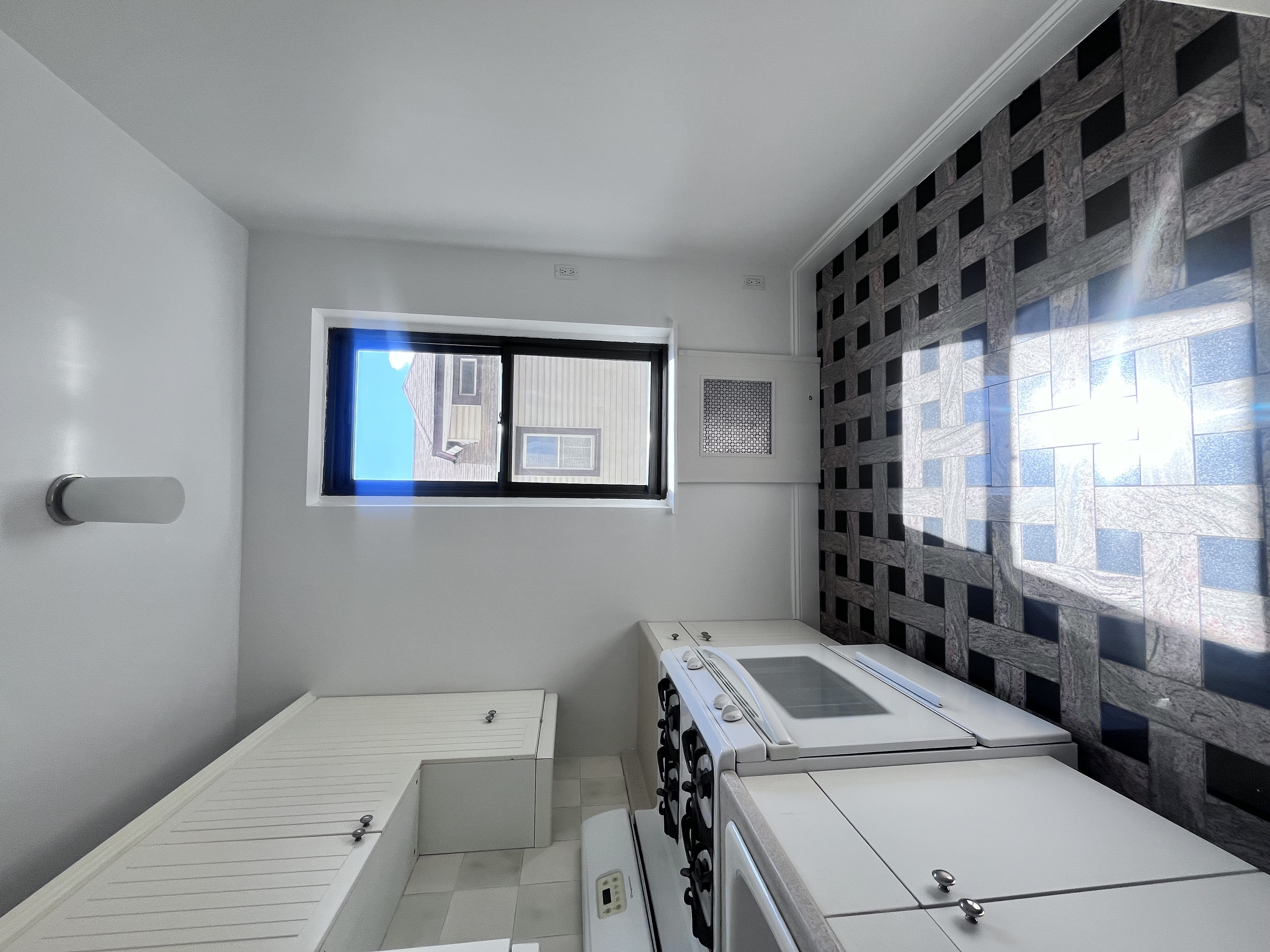 a kitchen with a checkered floor and white cabinets