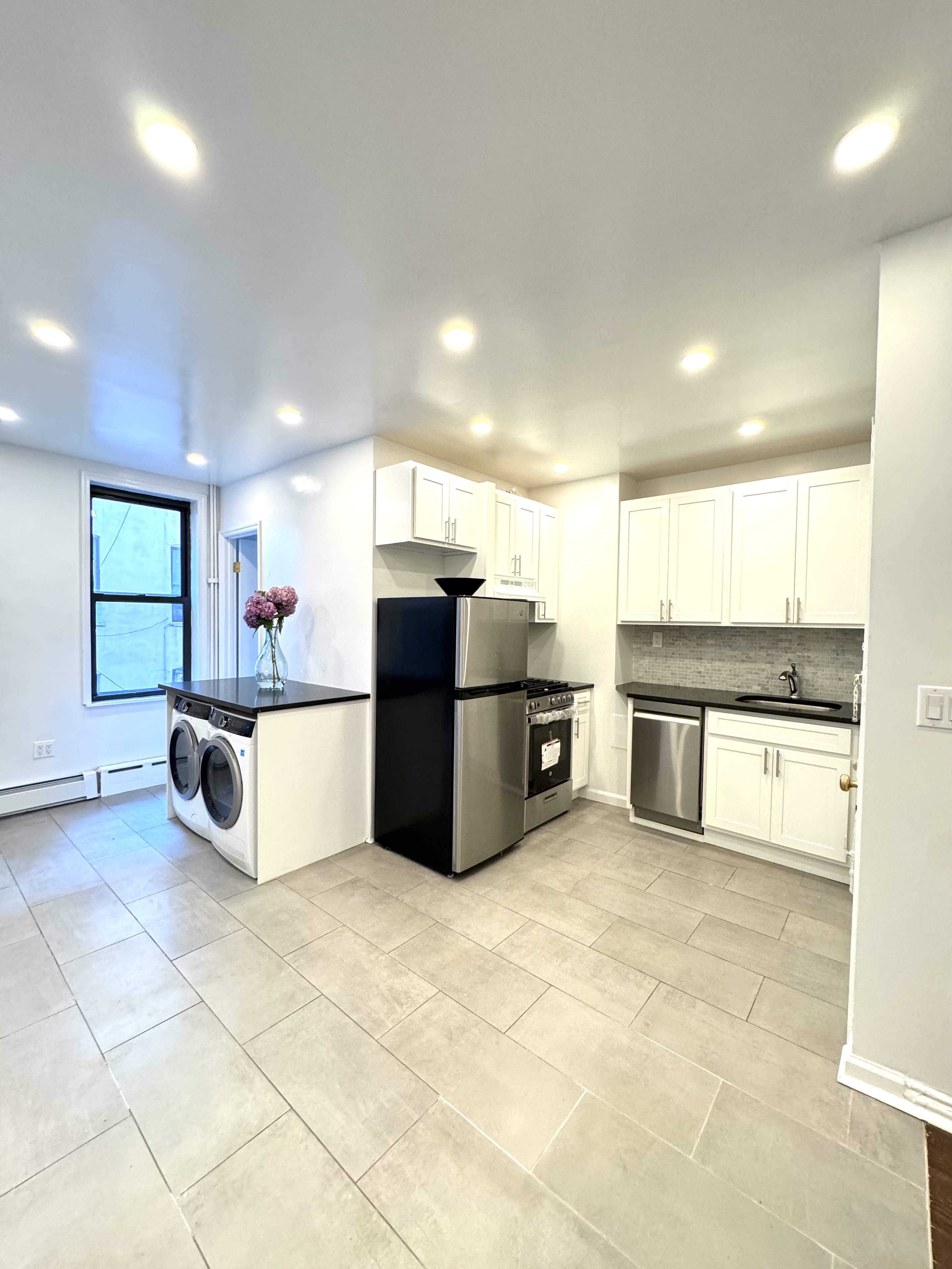 a large kitchen with stainless steel appliances a large counter top