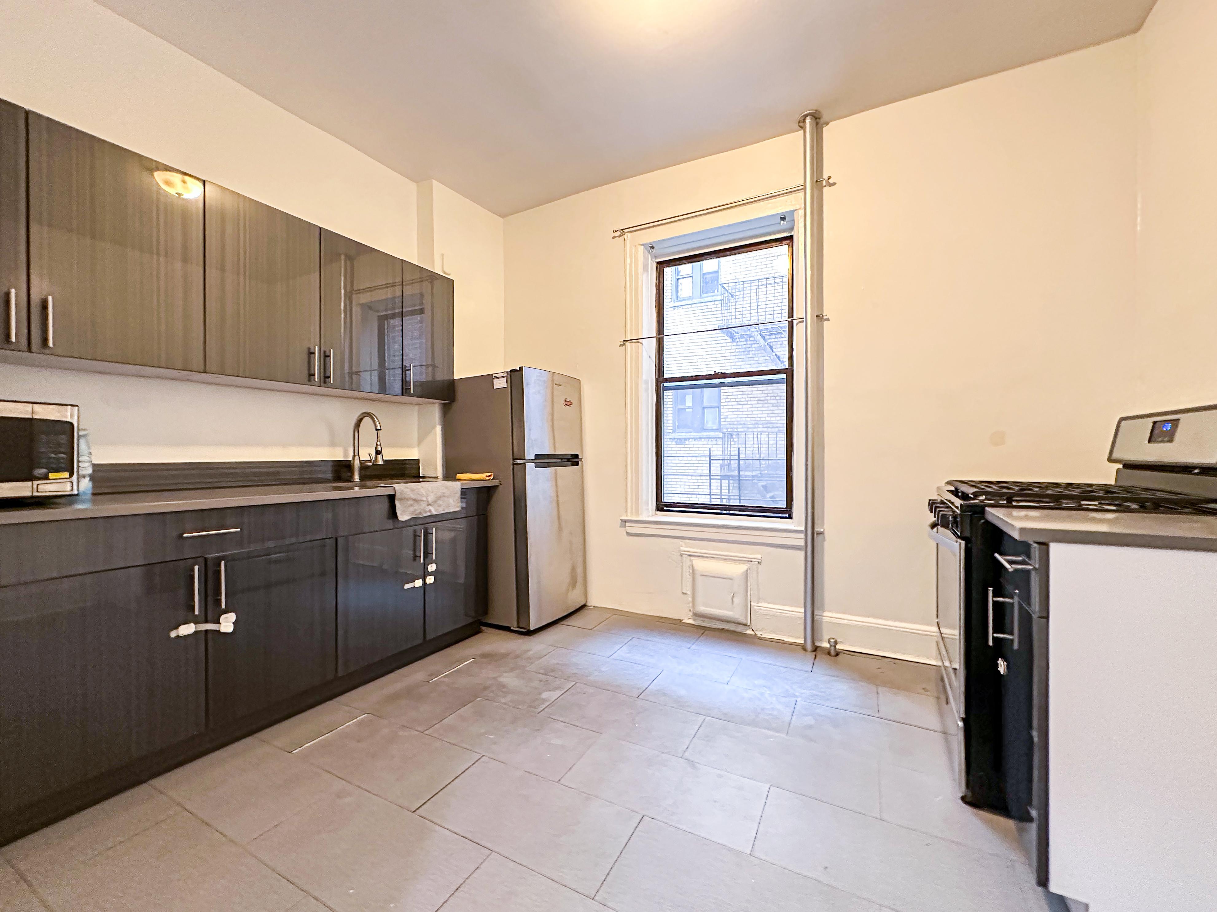 a kitchen with a refrigerator and a stove top oven