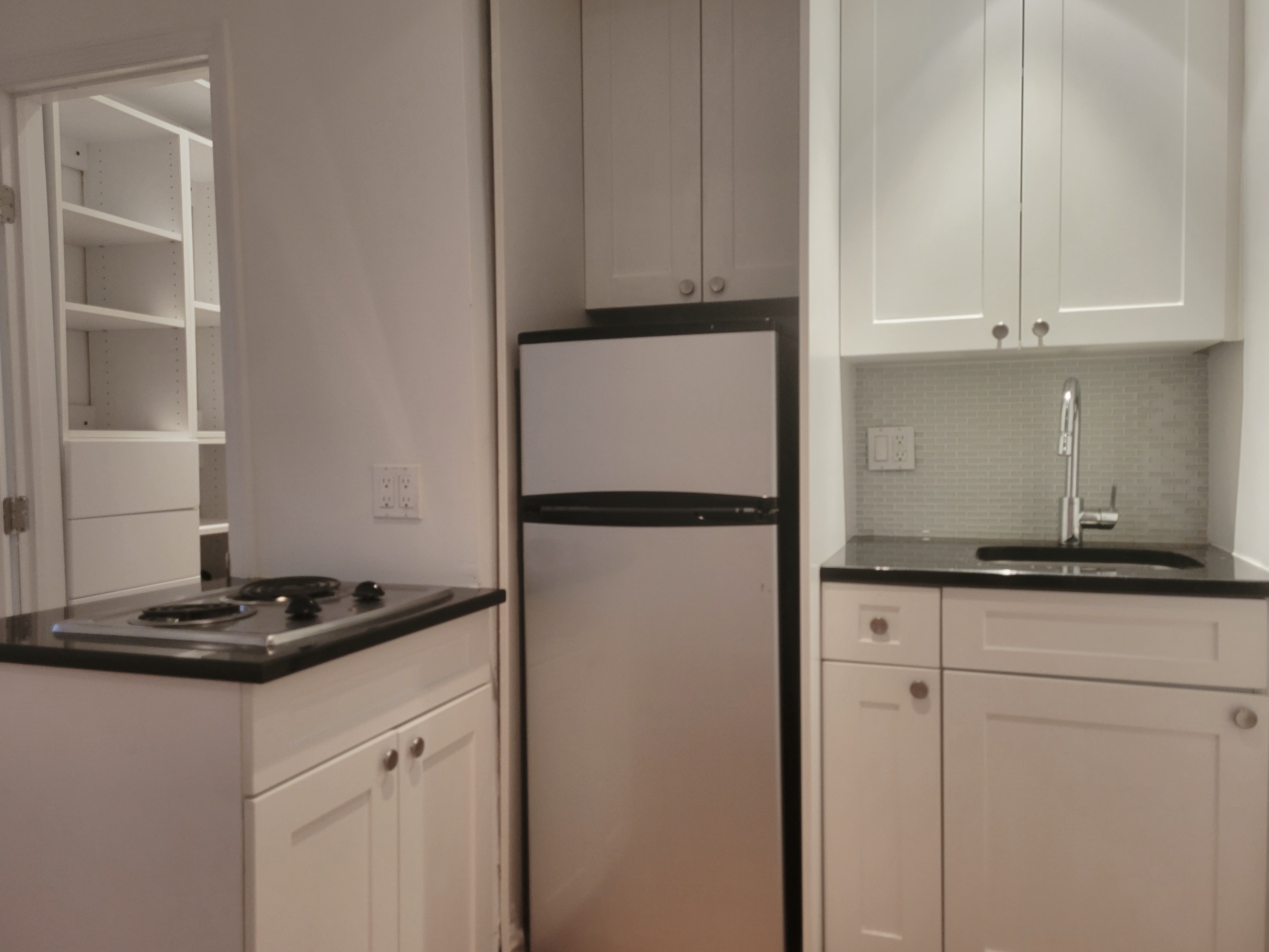 a kitchen with granite countertop cabinets and refrigerator