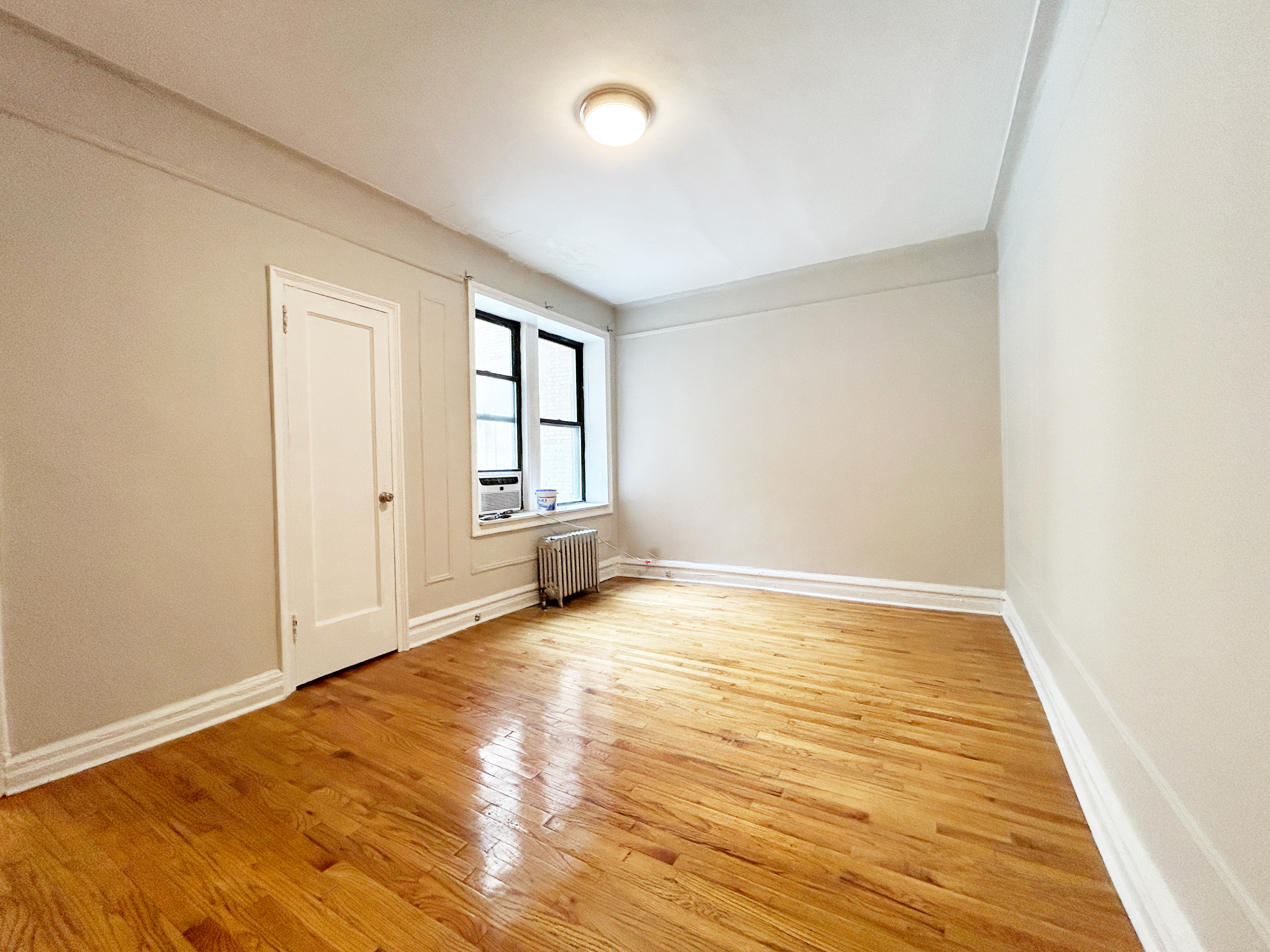 an empty room with cabinet and windows