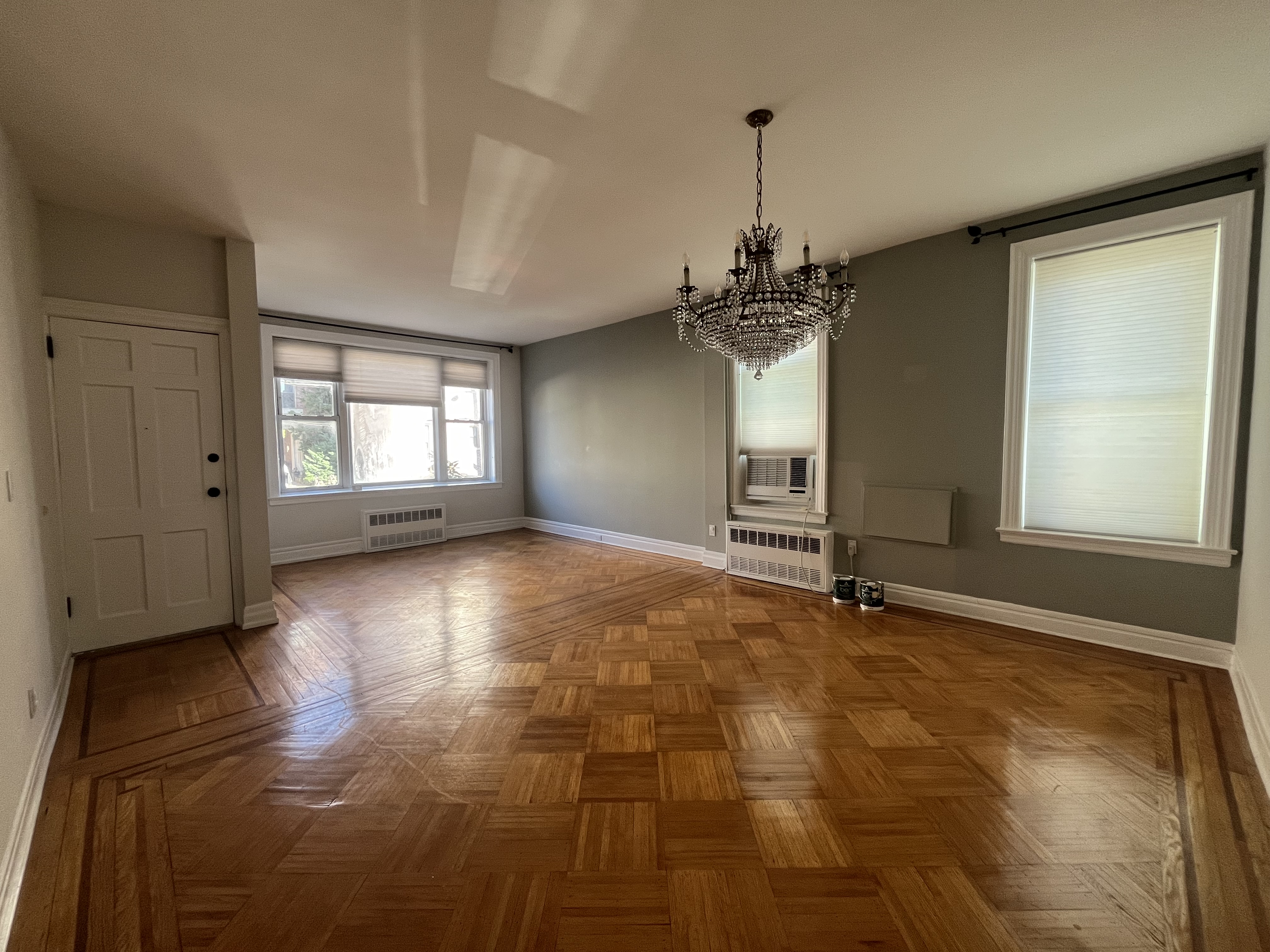 a view of an empty room with window and wooden floor