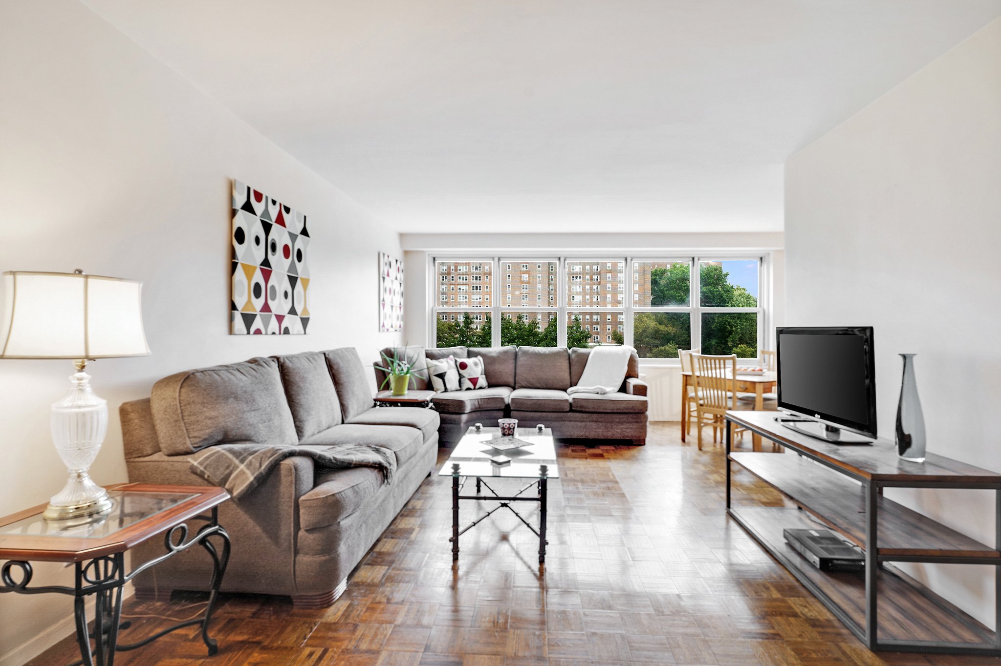 a living room with furniture a flat screen tv and a window