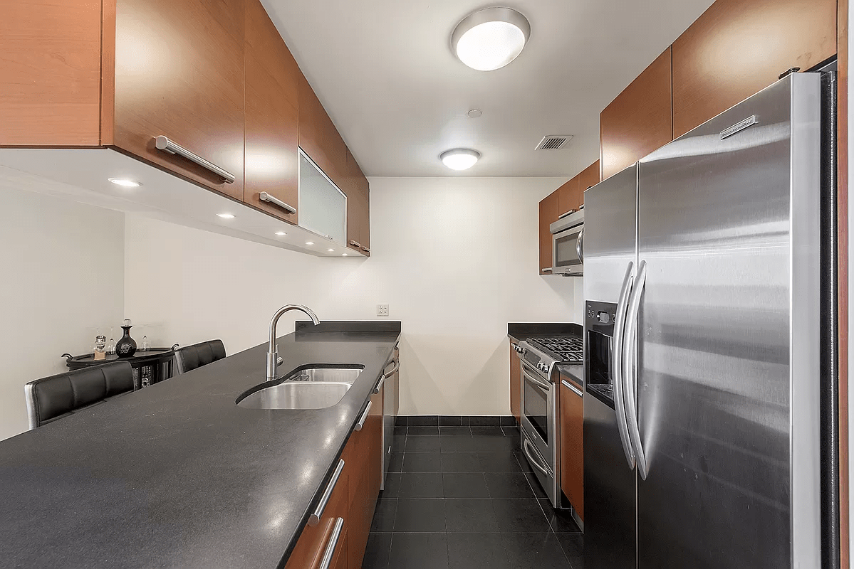 a kitchen with stainless steel appliances granite countertop a sink stove and refrigerator